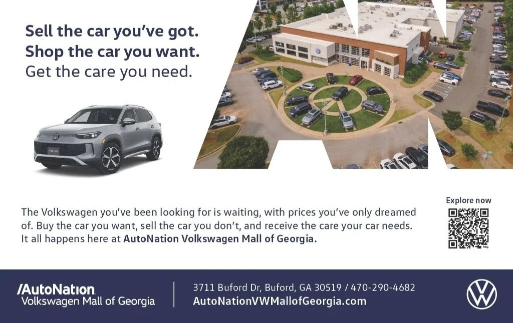 An advertisement for AutoNation Volkswagen of Georgia. The ad features a gray Volkswagen SUV, a large aerial photo of the dealership with multiple cars in the parking lot, and text promoting selling and buying cars. The dealership's address and QR code are also visible.