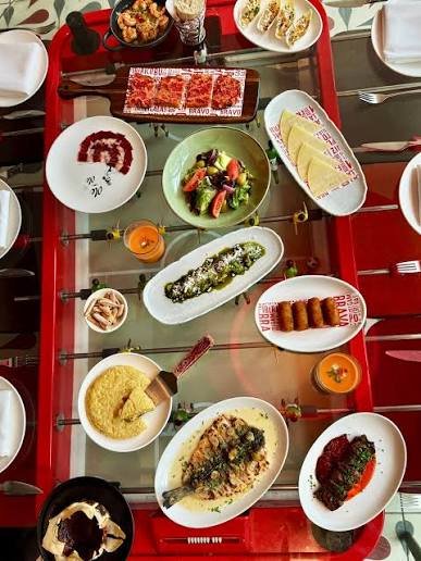 Chinese restaurant table with various dishes including sushi, fried rolls, salad, rice, and desserts.