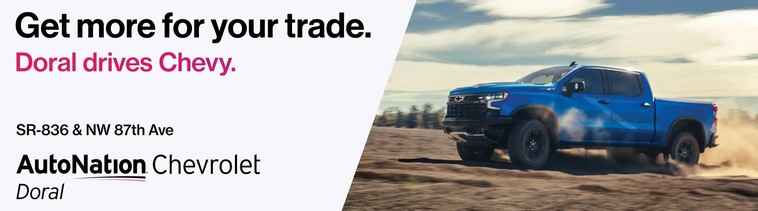 An advertisement for Doral Chevrolet featuring a blue Chevrolet pickup truck driving on a dirt road with dust behind it, under a partly cloudy sky.