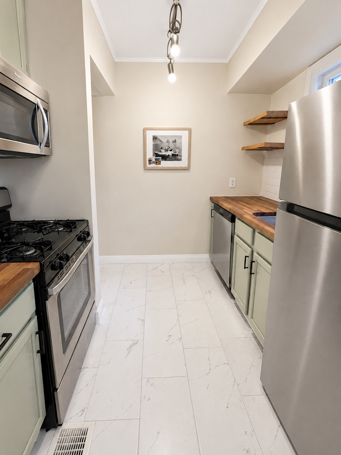 Green kitchen cabinets, butcher block countertop, tile flooring, stainless steel appliances