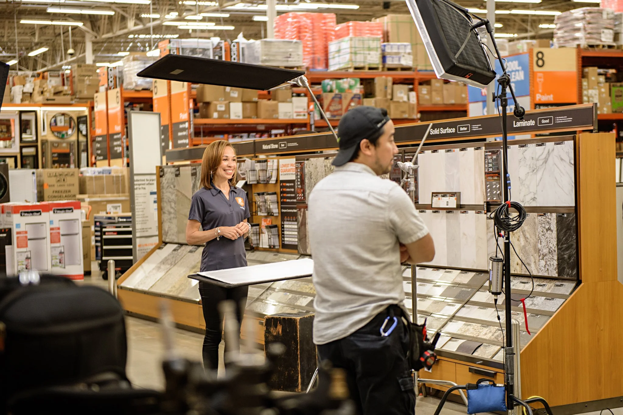 Kelley on set inside a hardware store, smiling before delivering her lines to camera.