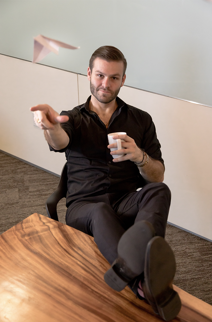 Gregory Melon, marketing executive throws a paper airplane towards the camera