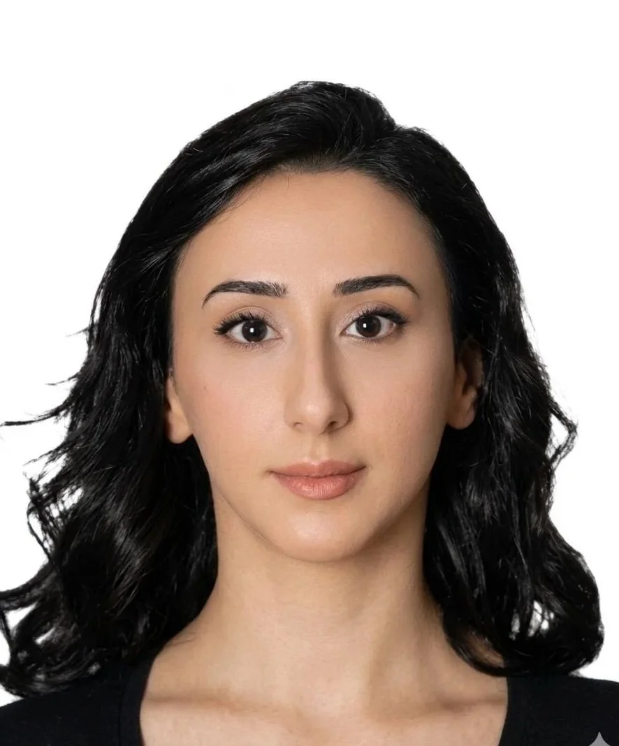 Kameraya bakan, kısa siyah saçlı, açık tenli kadın portresi.