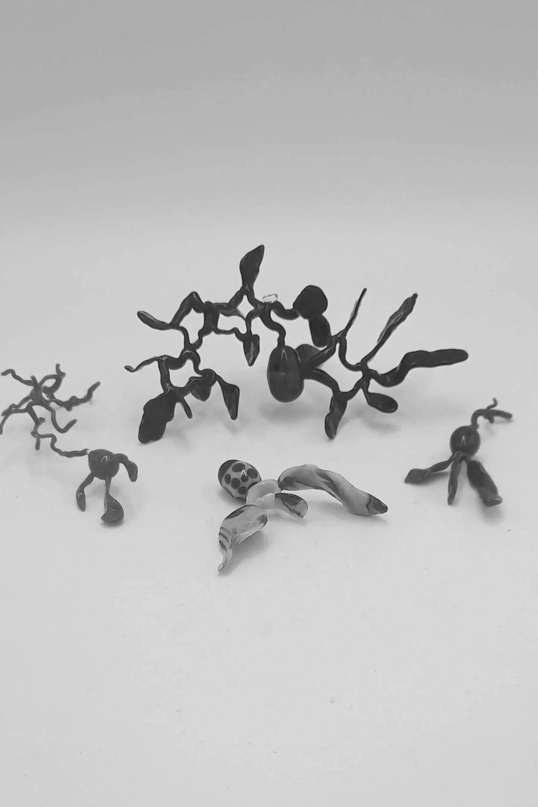 Black and white abstract sculpture resembling intertwined branches and organic shapes, arranged against a plain background.