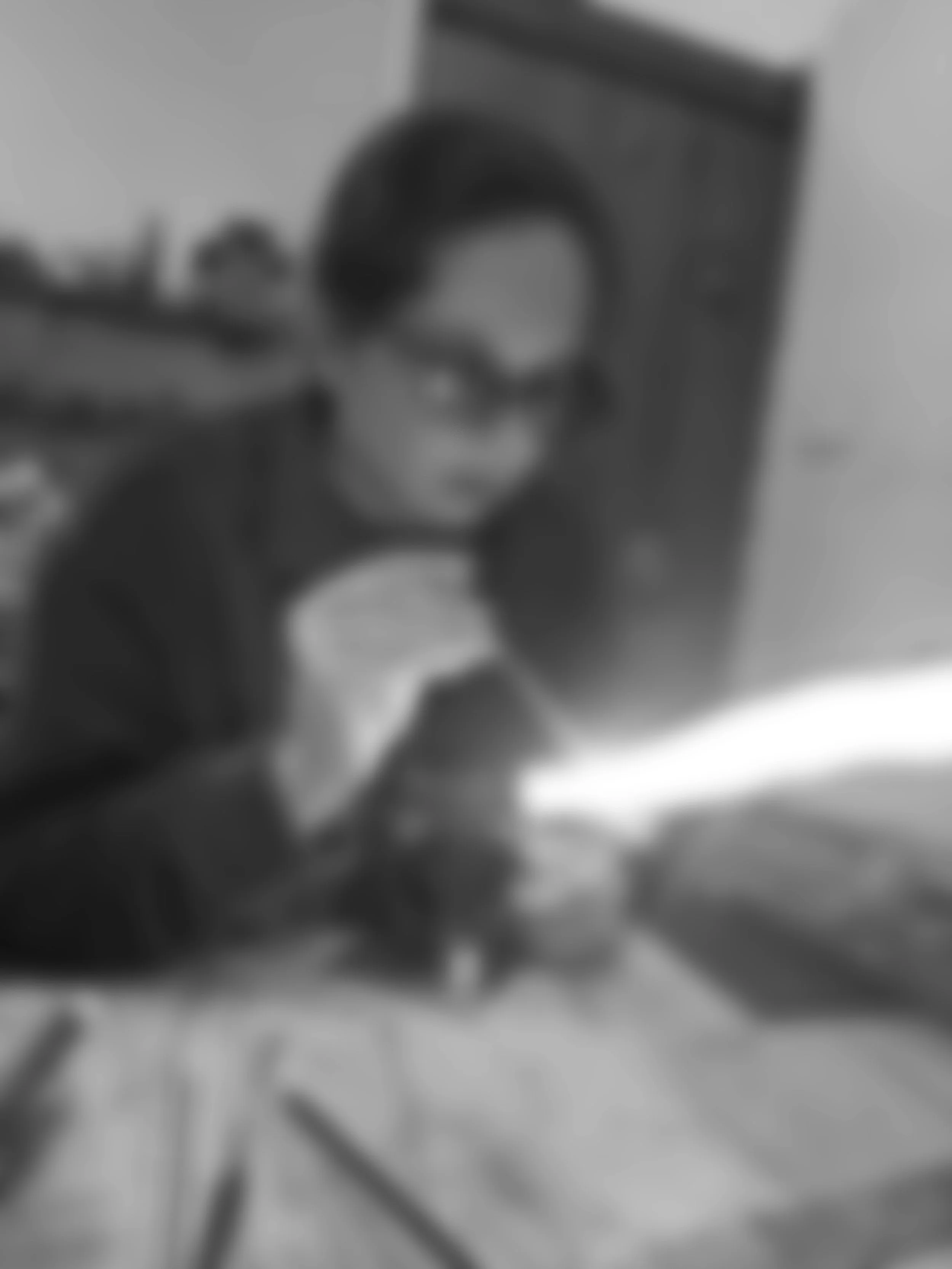 A blurry black and white photo of a person taking a selfie in front of a mirror.