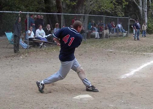 A boy in a blue baseball jersey with the number 41 running across a baseball field.
