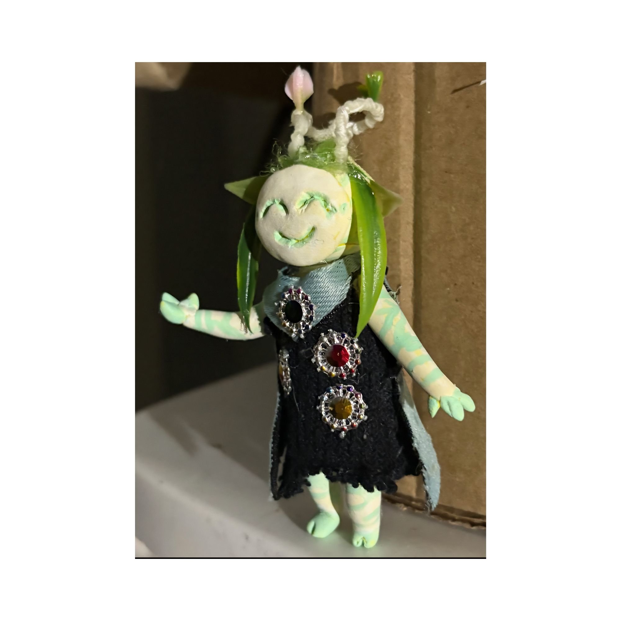 Flora, Bingo’s handmade clay character, shown from the front in a black jeweled outfit.