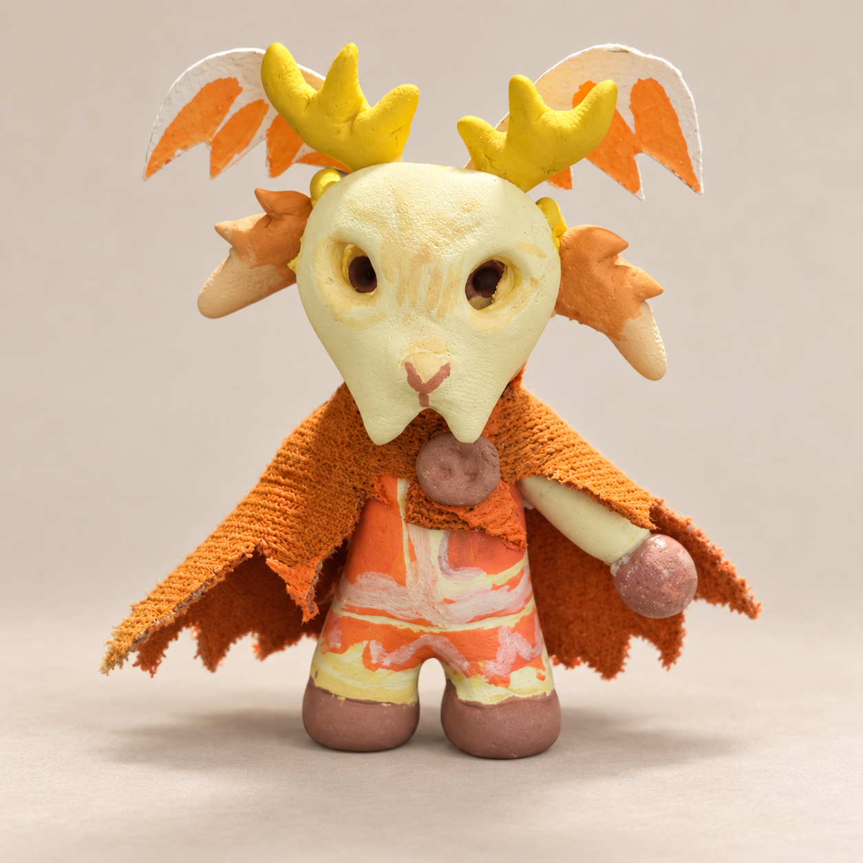 front.pngFront view of Fauna, Bingo’s handmade clay character, with yellow antlers and an orange cape.