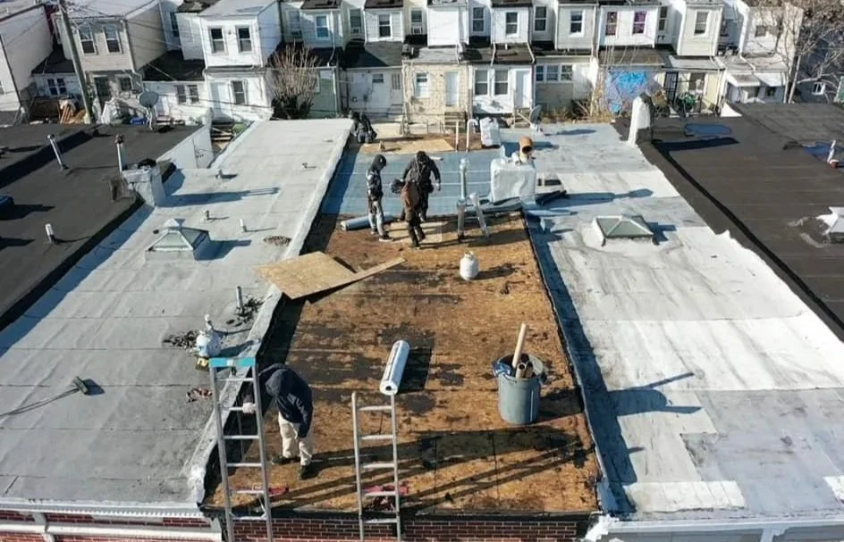 Workers of City Builders installing a new section of roofing on a baltimore city md home.