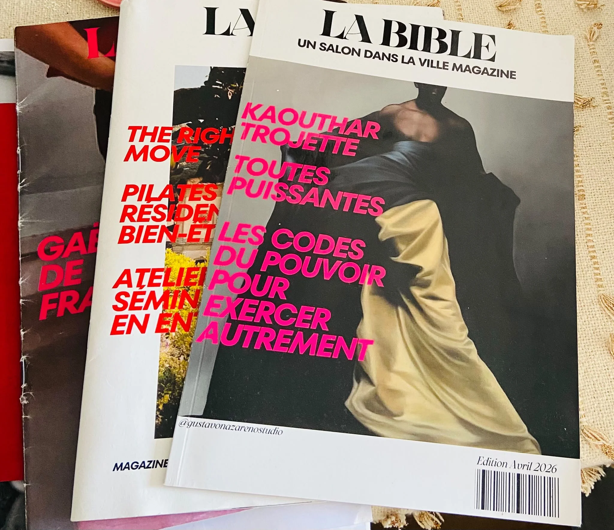 Magazines empilés avec des couvertures en gros caractères colorés, notamment un magazine nommé "La Bible" avec une photo d'une personne portant un hoodie, et un autre avec un titre en rouge "The Right Move".