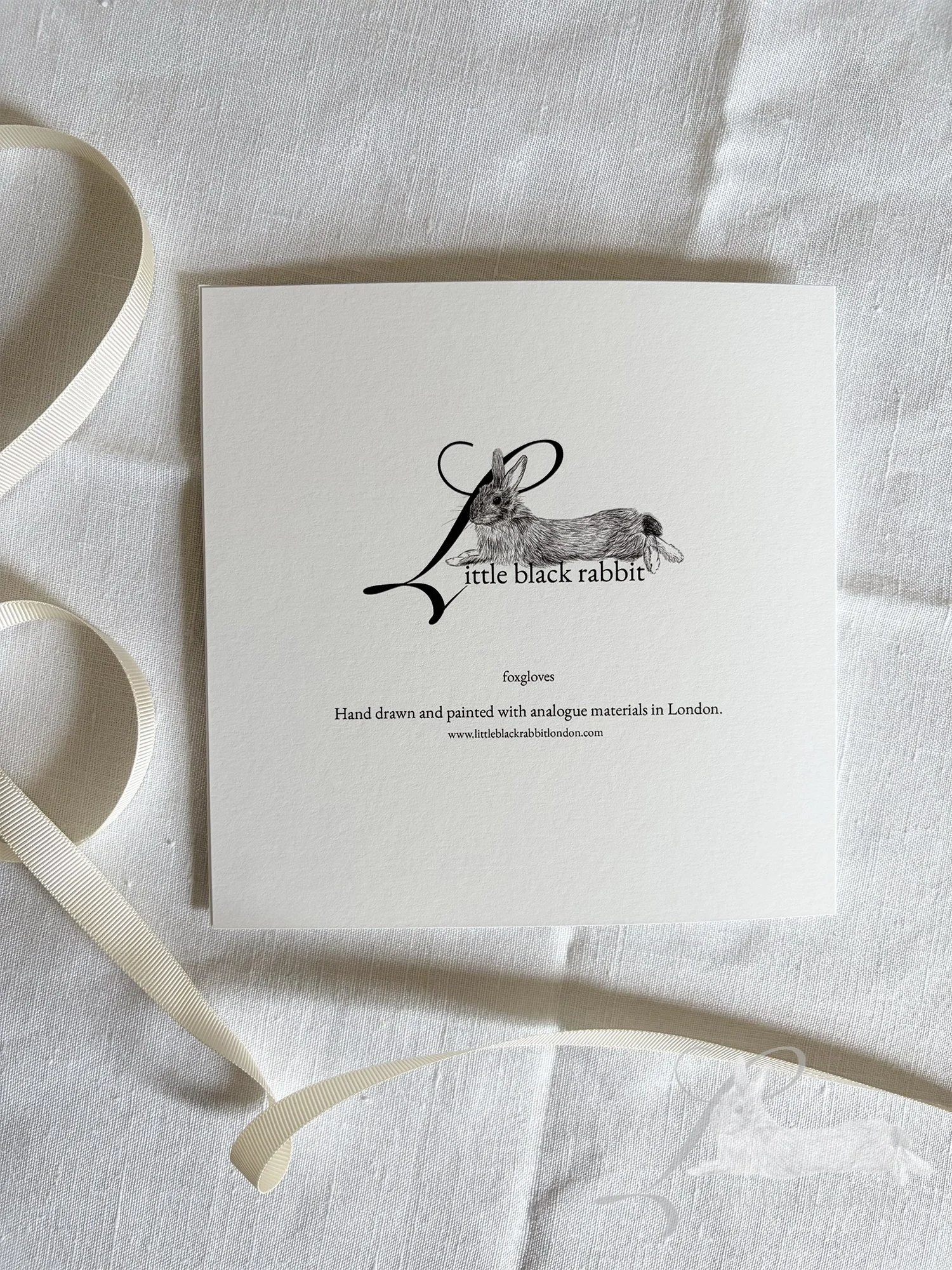 Greetings card sitting face down on a table showing the Little Black Rabbit logo.