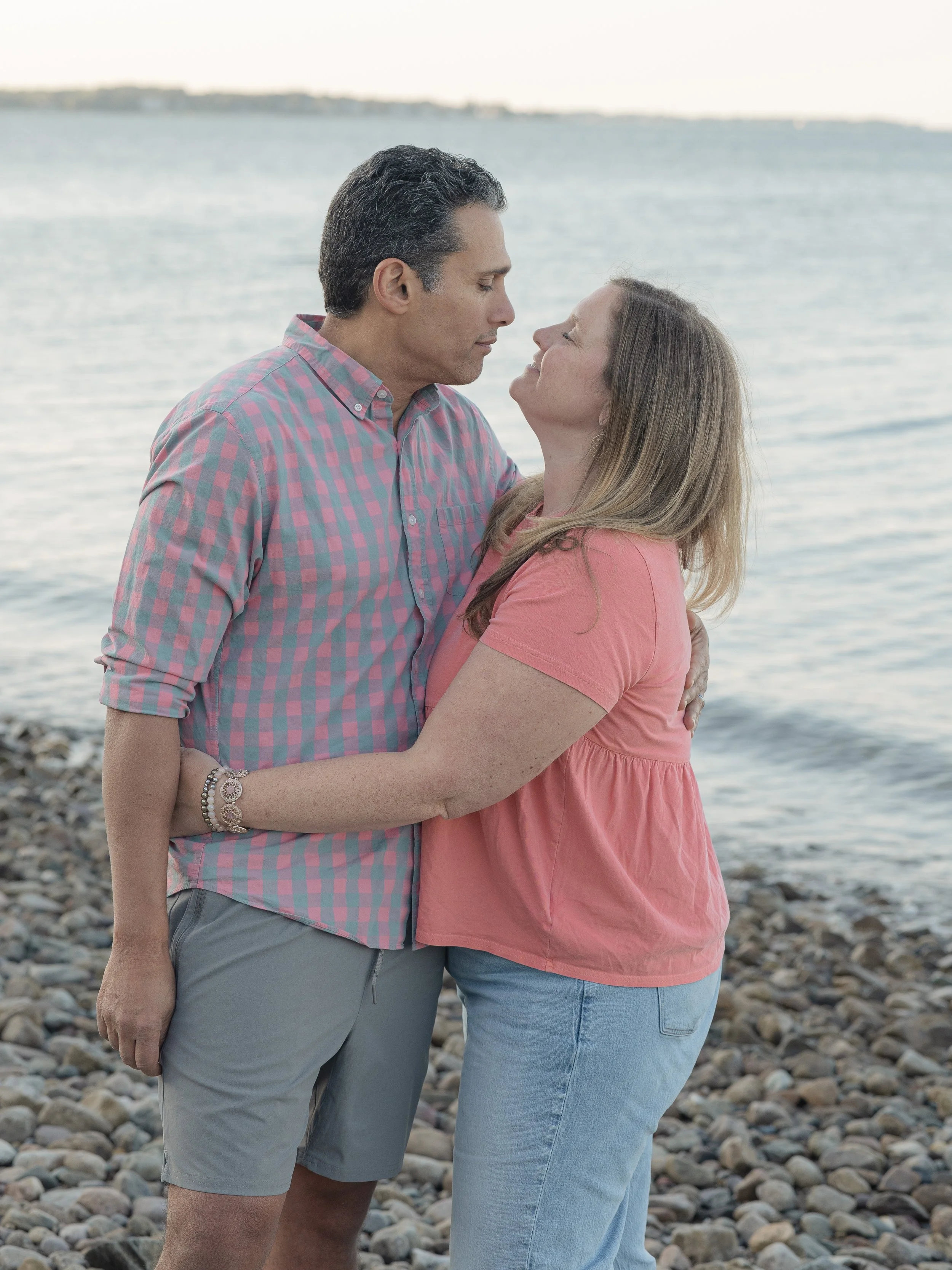 Couple embracing at the beach in pink matching shirts