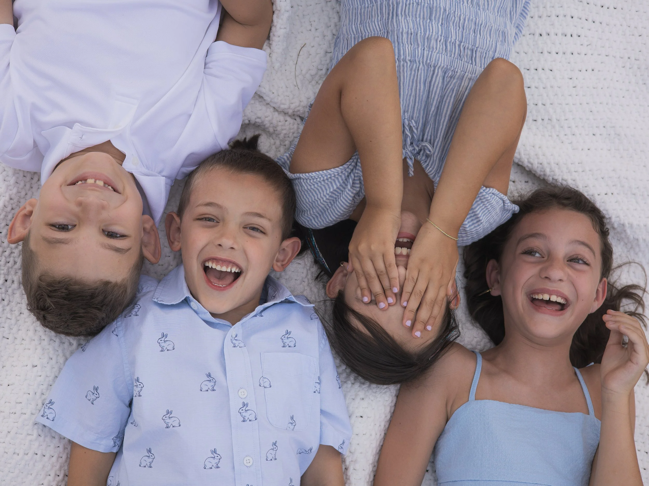 Four kids in blue shirts shot from above at a farm 