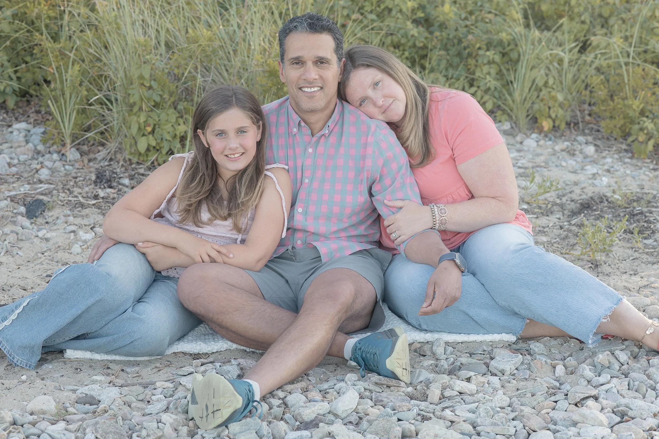 A family of three in matching outfits at the beach 