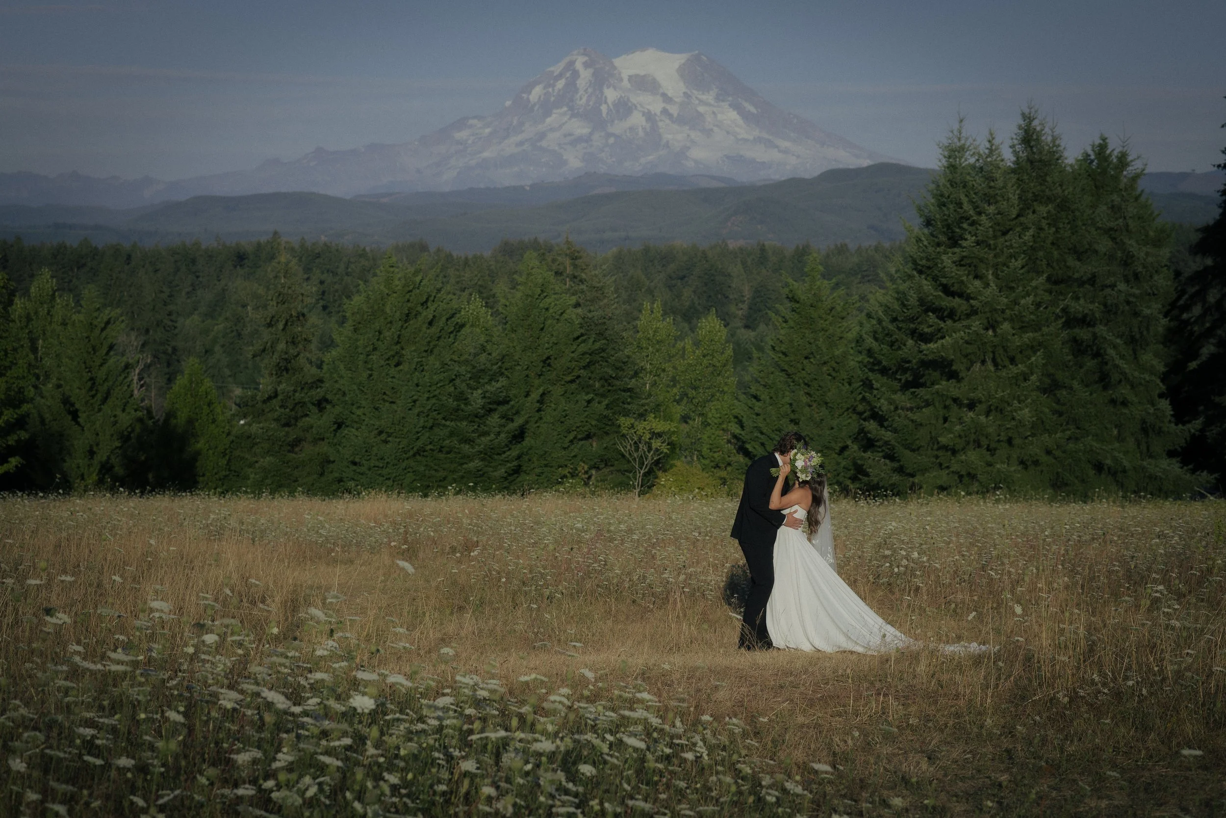 Elopement of man and woman in a field in front of Mt. Rainier in Washington. 