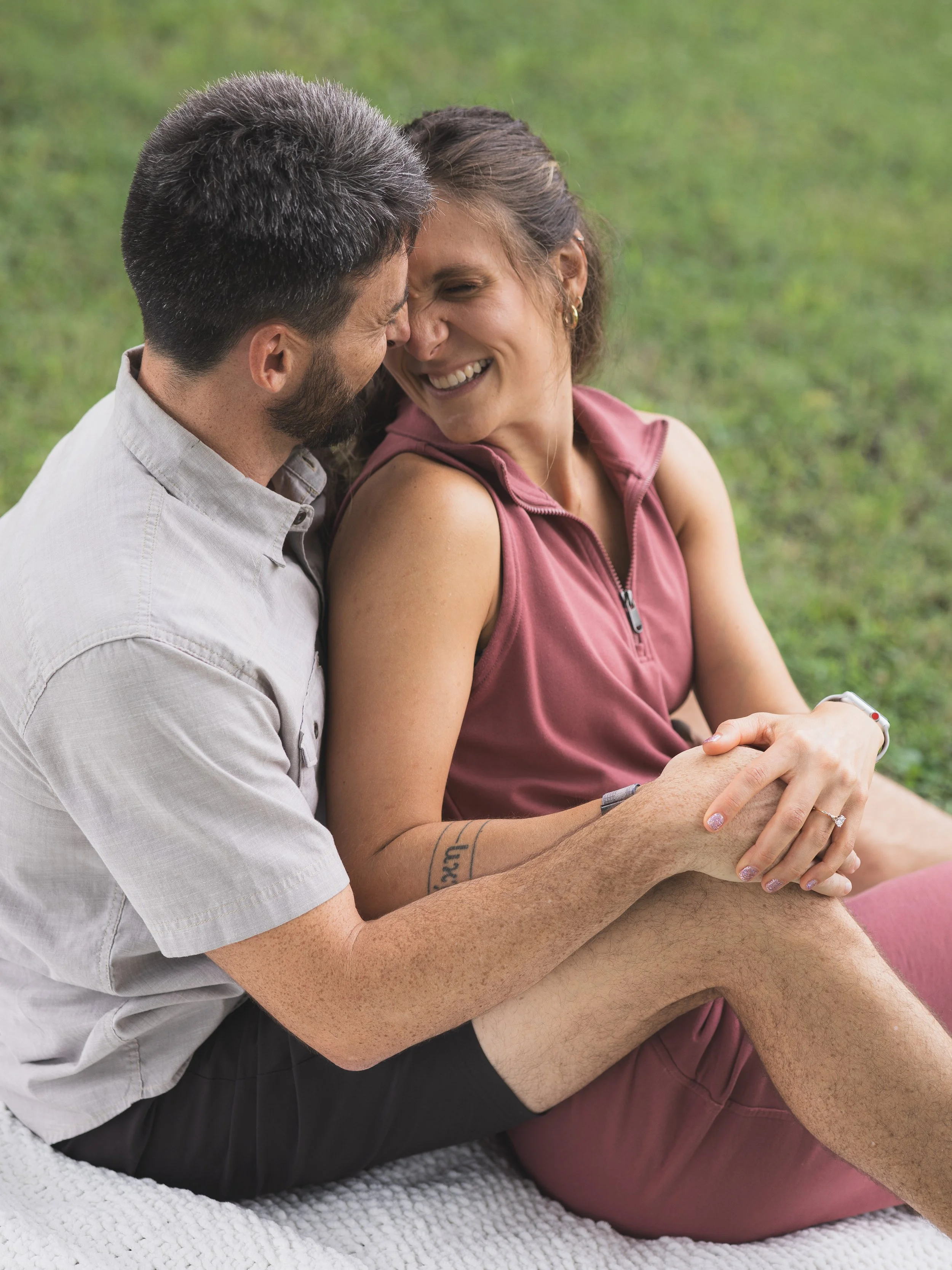 Man and woman sitting cozy in a park after getting engaged