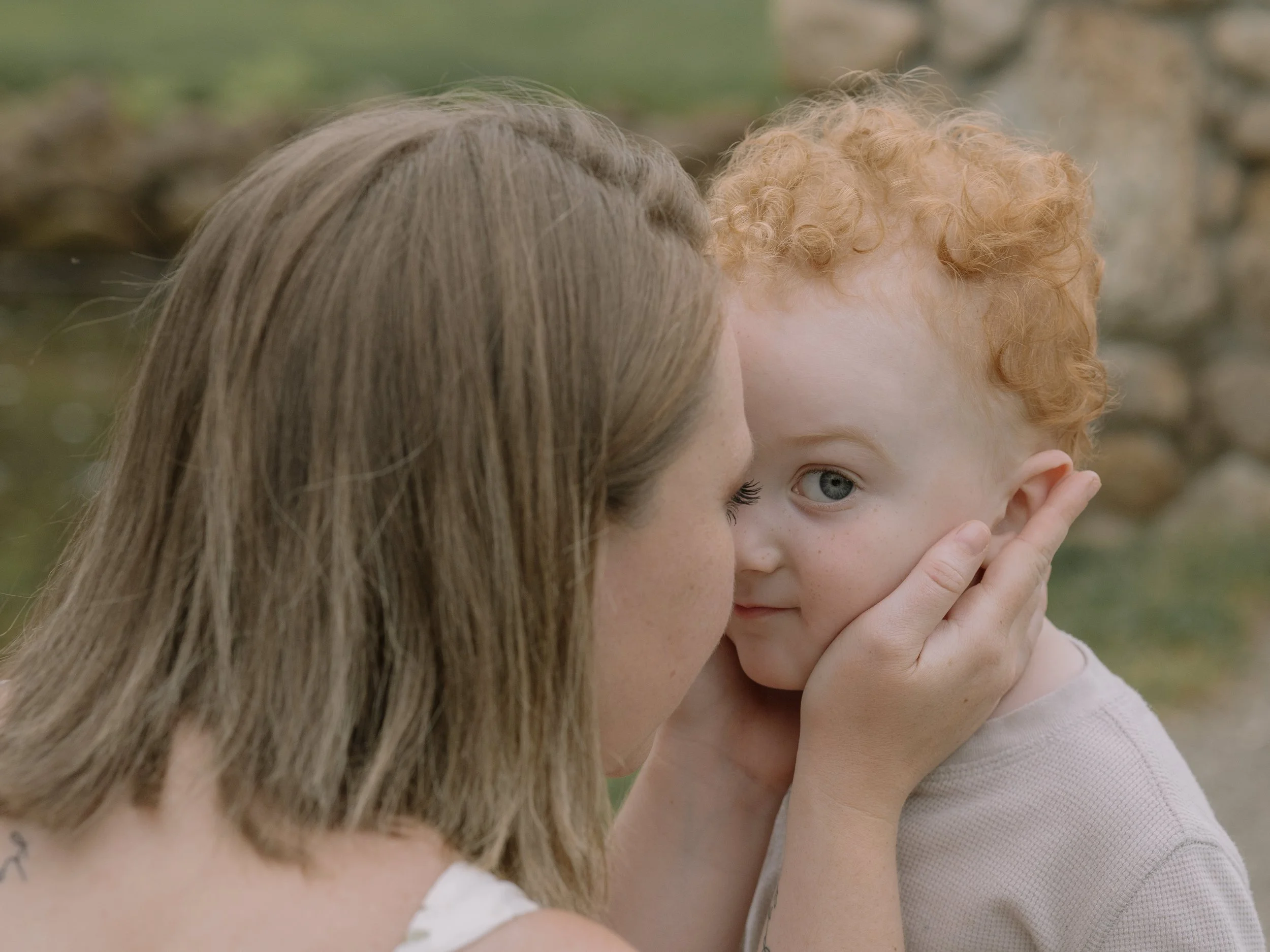 Mom holding toddler son's face in her hands