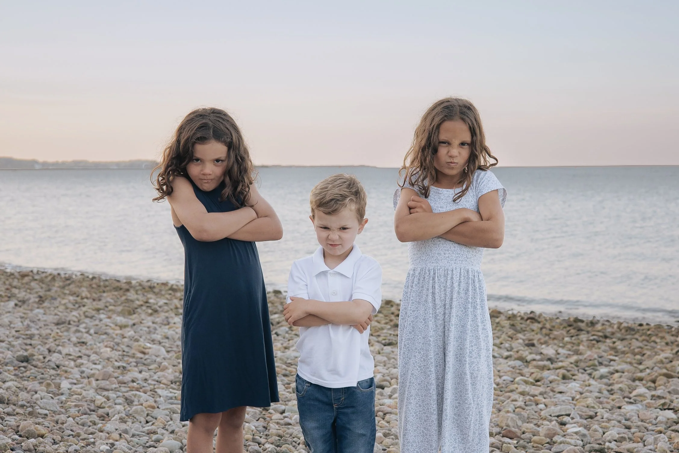 Three siblings at the beach making mad faces for the camera
