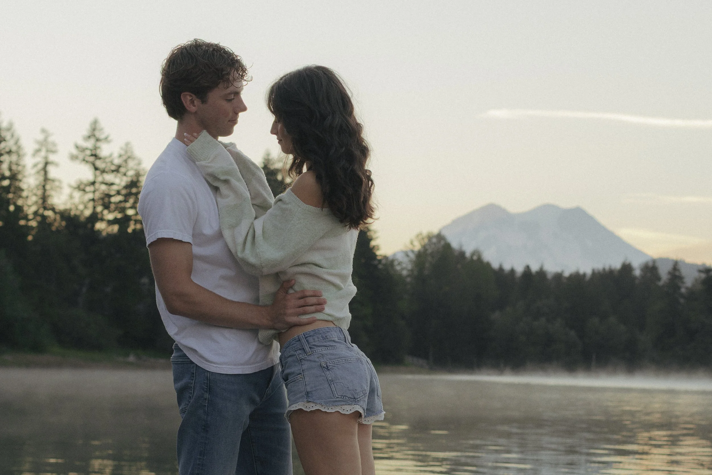 Man and woman embracing in on a lake in front of Mt. Rainier