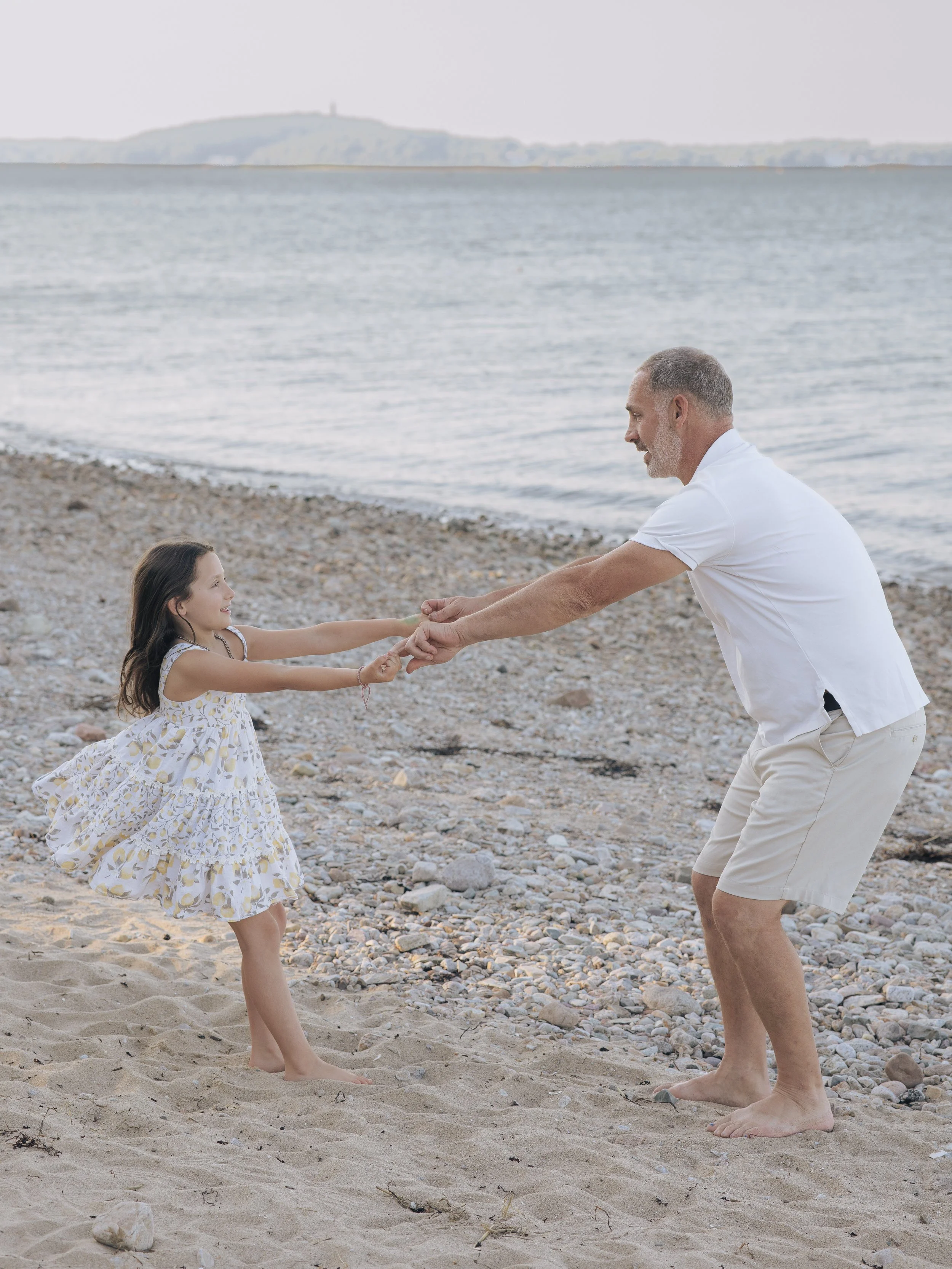 Father and daughter dancing together at the beach