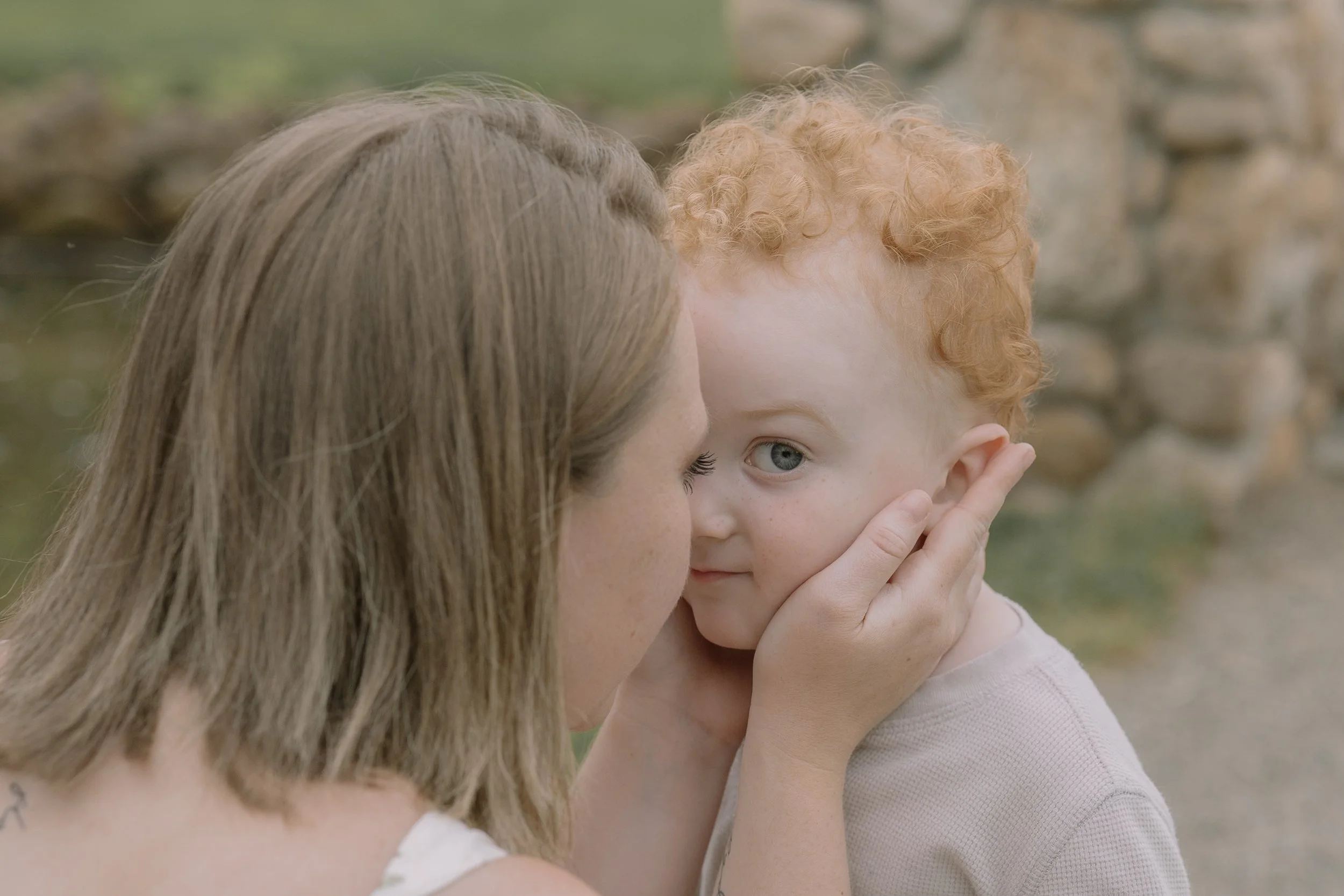 Mom holding toddler son's face in her hands