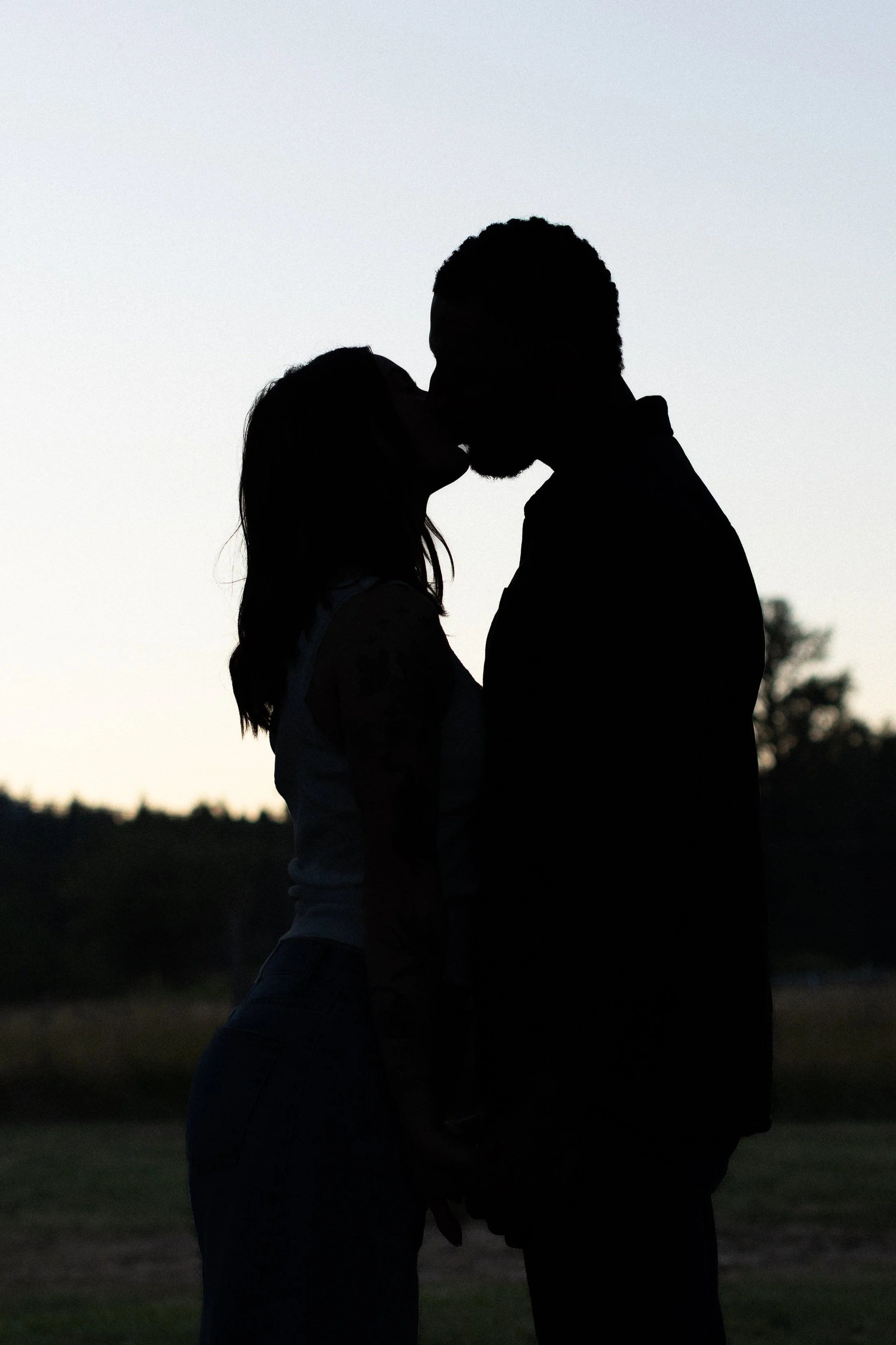 Silhouette of man and woman kissing. 