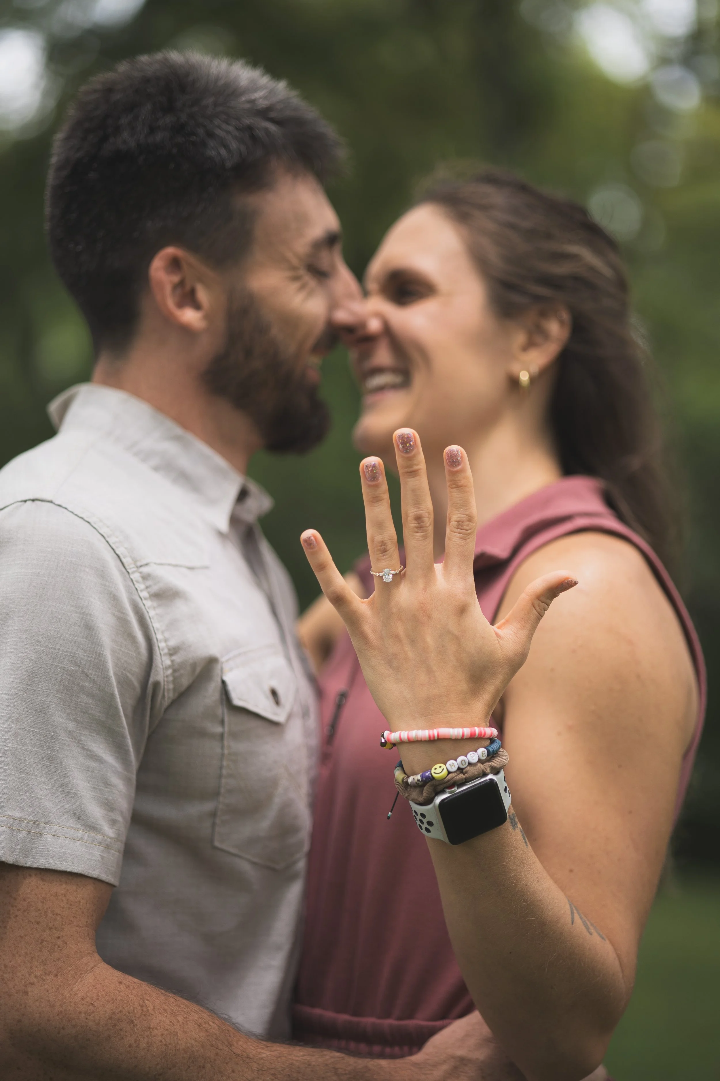 Woman showing off her new engagement ring after getting engaged in a park