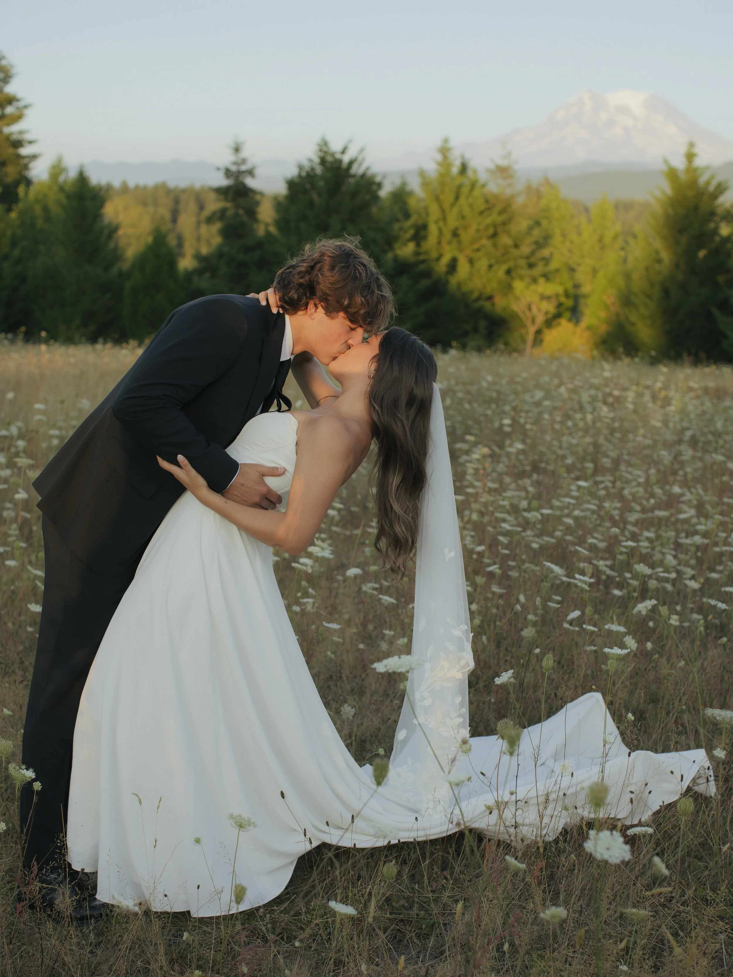 Groom dipping bride and kissing her in front of Mr. Rainier.