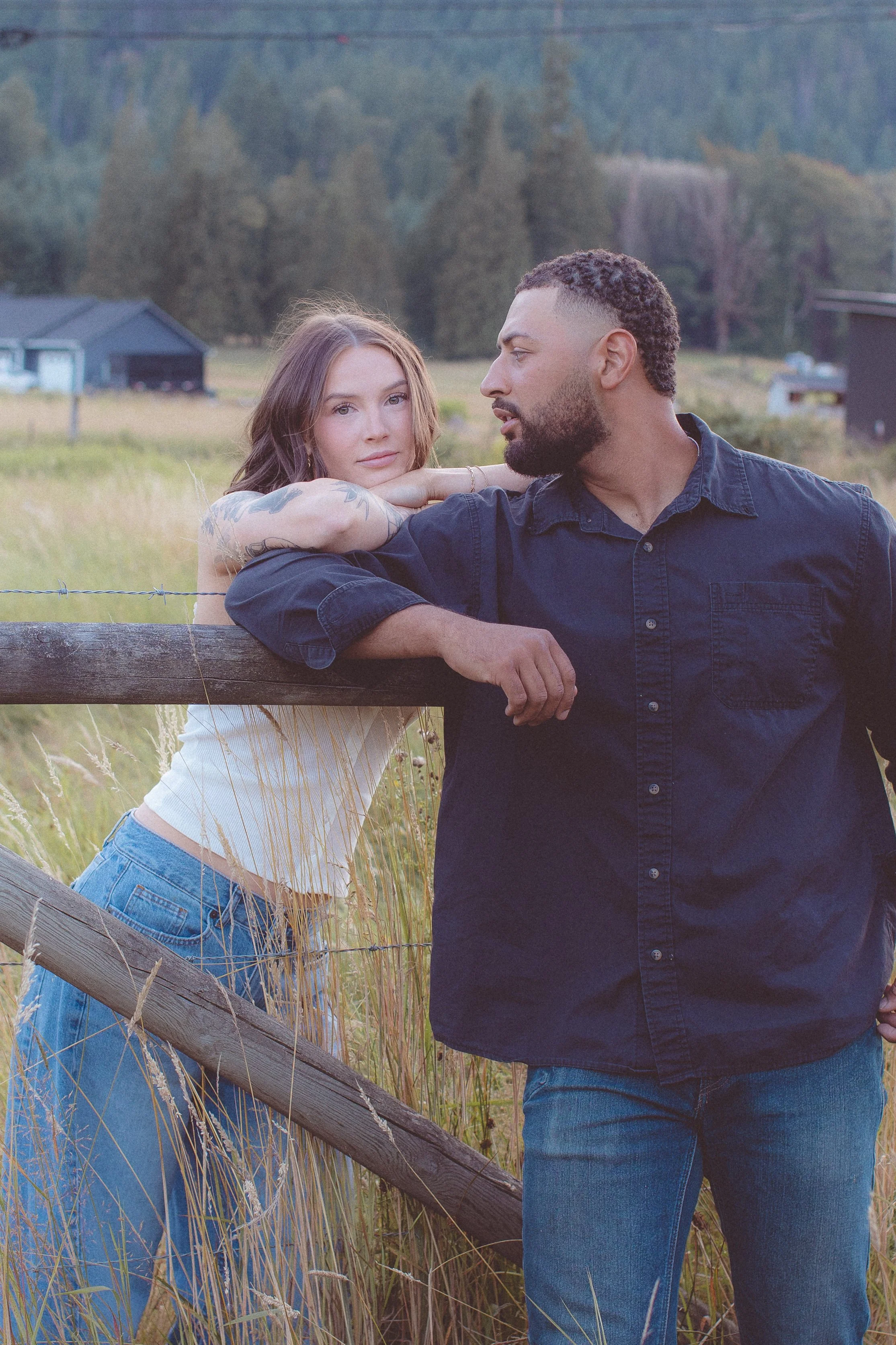 Man looking at woman longingly in a grass field. 