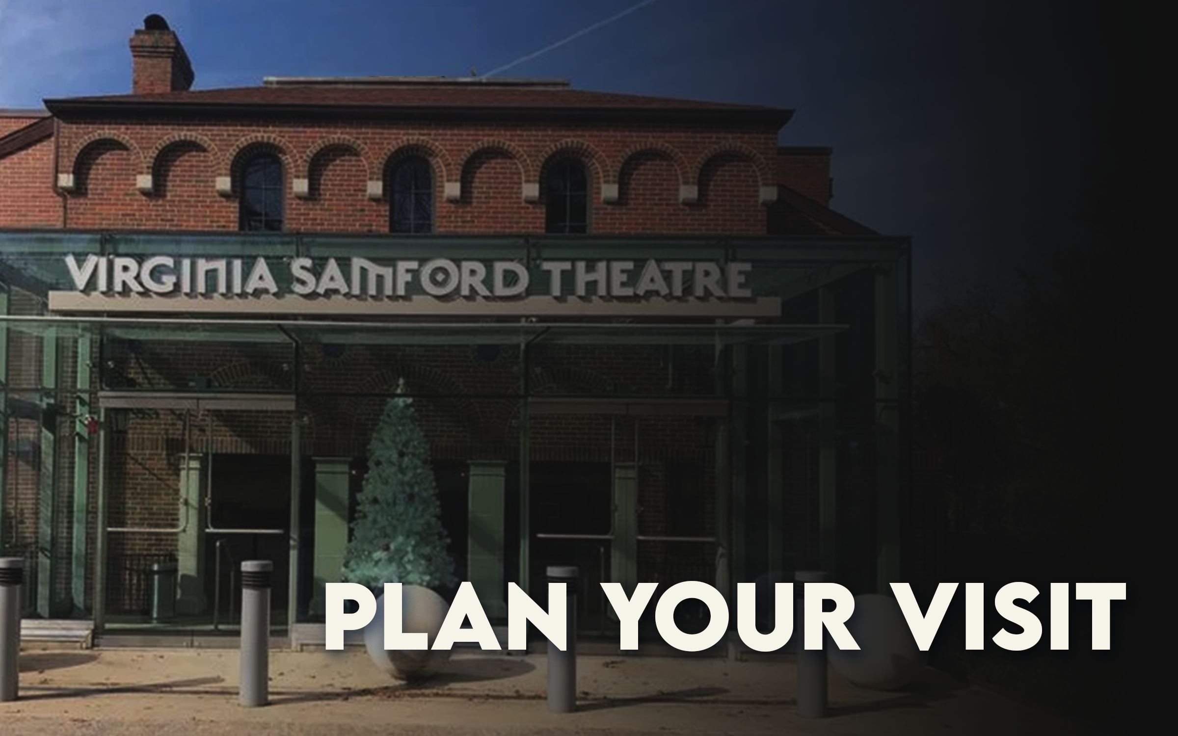 The image shows the Virginia Samford Theatre, a brick building with arched windows, with a modern glass entrance featuring a sign that says 'Virginia Samford Theatre'. There are some trees and a sidewalk in front of the theatre.