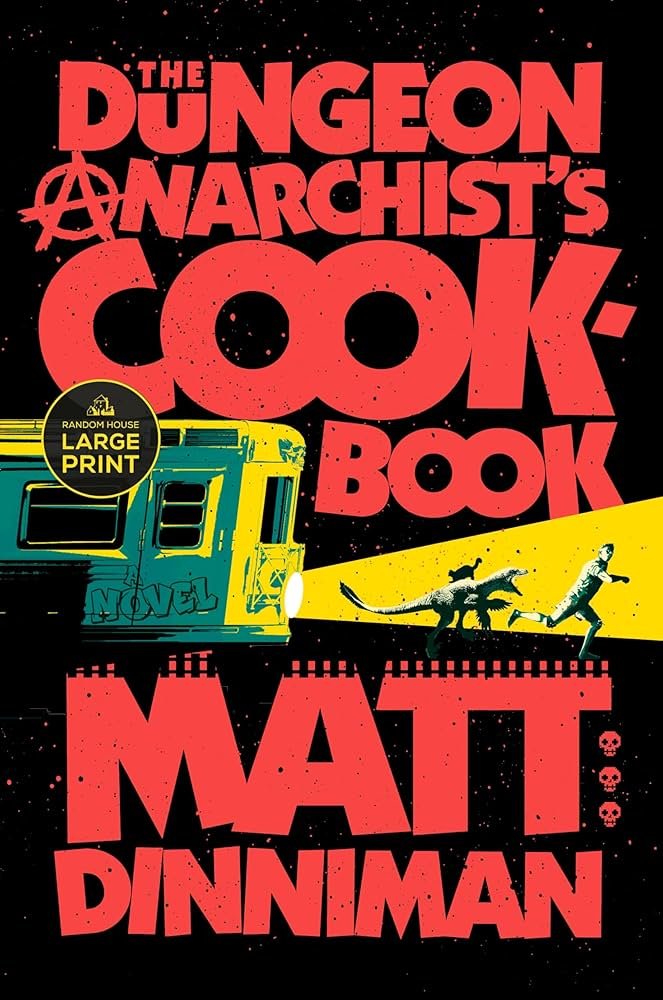 Book cover titled 'The Dungeon Anarchist's Cook Book' by Matt Dinman, featuring a stylized yellow food truck with graffiti, a running person and dinosaur underneath a yellow beam of light, with skull icons and a sticker indicating a large print edition.