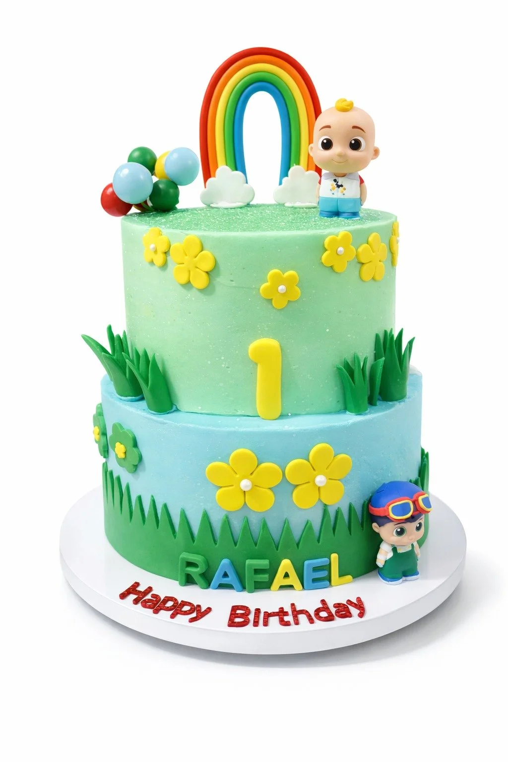 Colorful two-tiered birthday cake with rainbow, clouds, yellow flowers, green grass decoration, and two toy characters, one on top and one on the side. The cake features the name 'RAFAEL' and the message 'Happy Birthday' on the base.