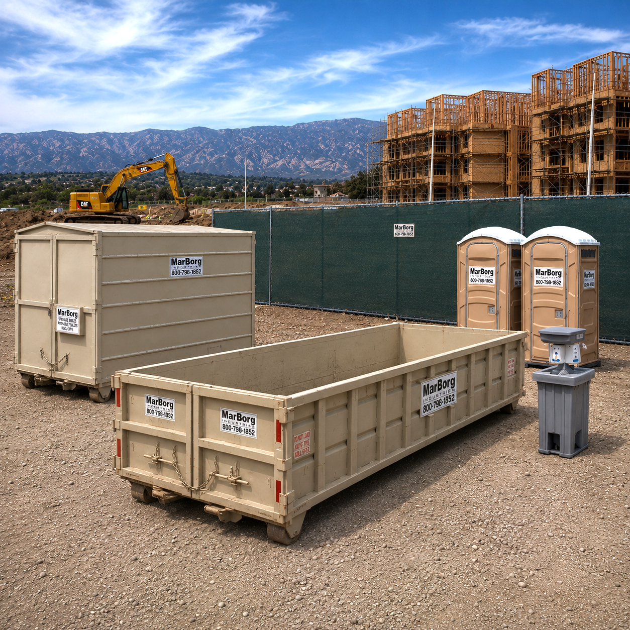 Construction site with portable toilets, shipping containers, and a bulldozer, with partially built wooden structures and mountains in the background.