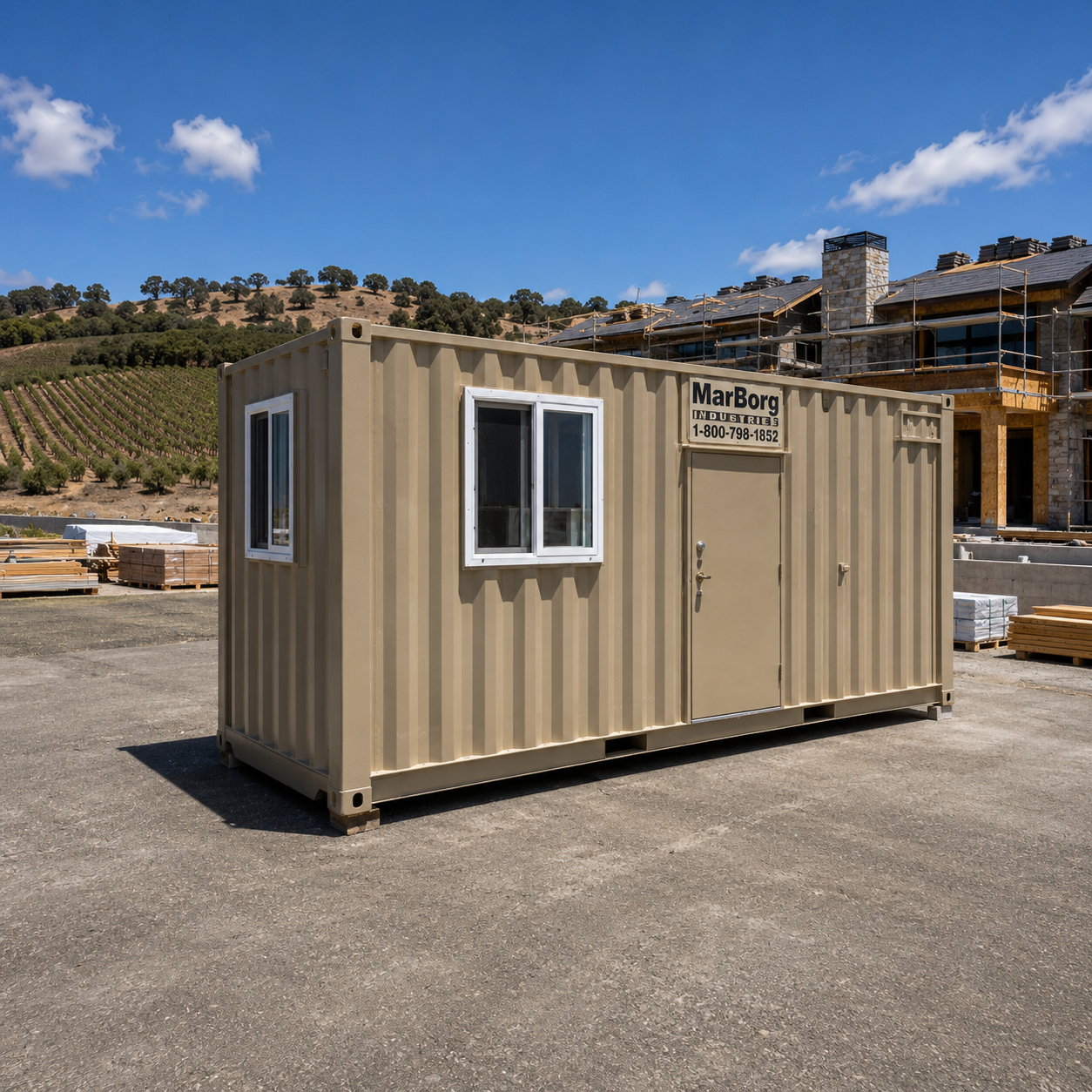 A large steel site office sits in front of a residential construction project of a large home on the Central Coast. Vinyards in the background under a blue sky.