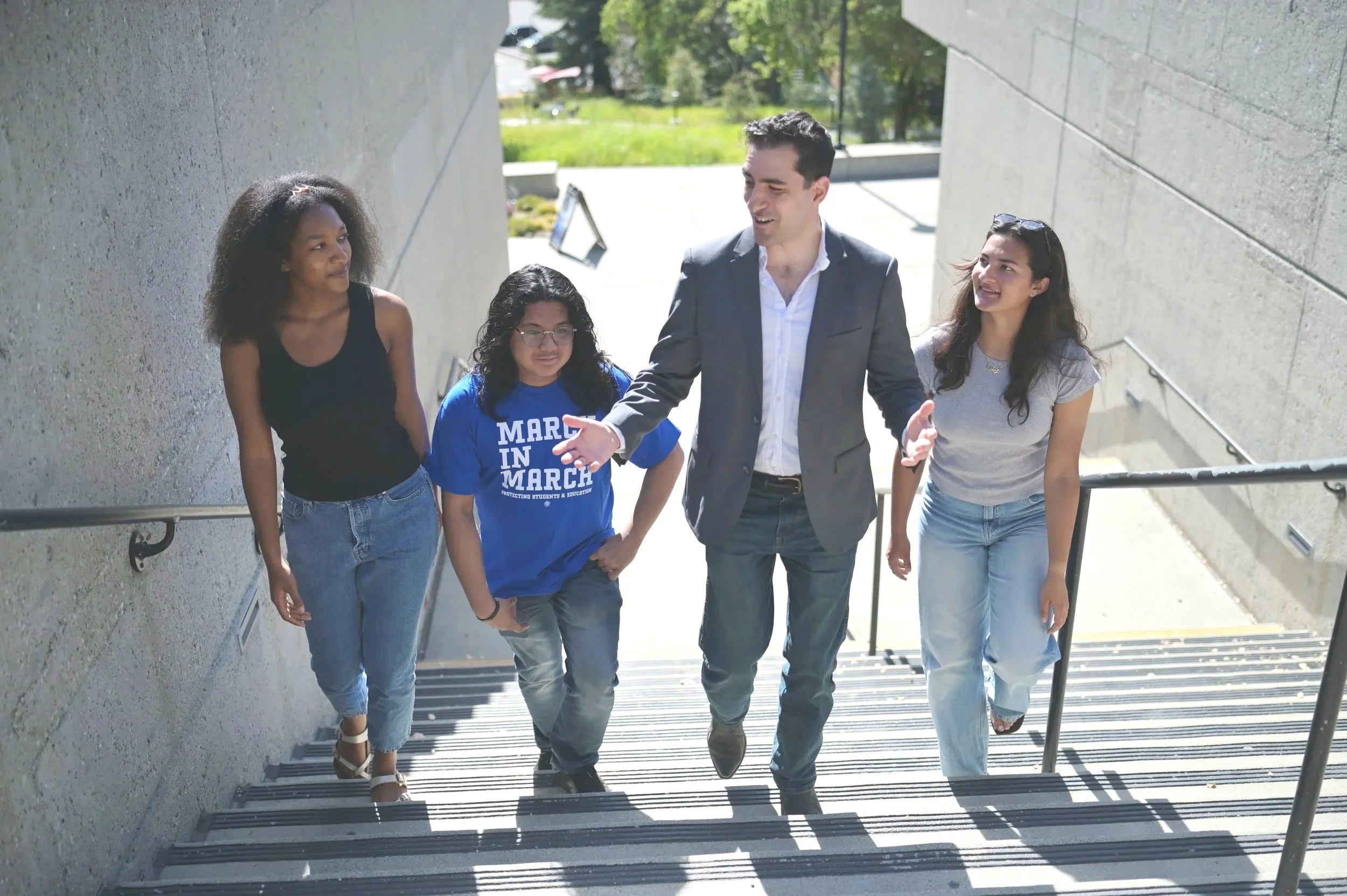 Alexander Gvatua walks up stairs at De Anza College with three college students.