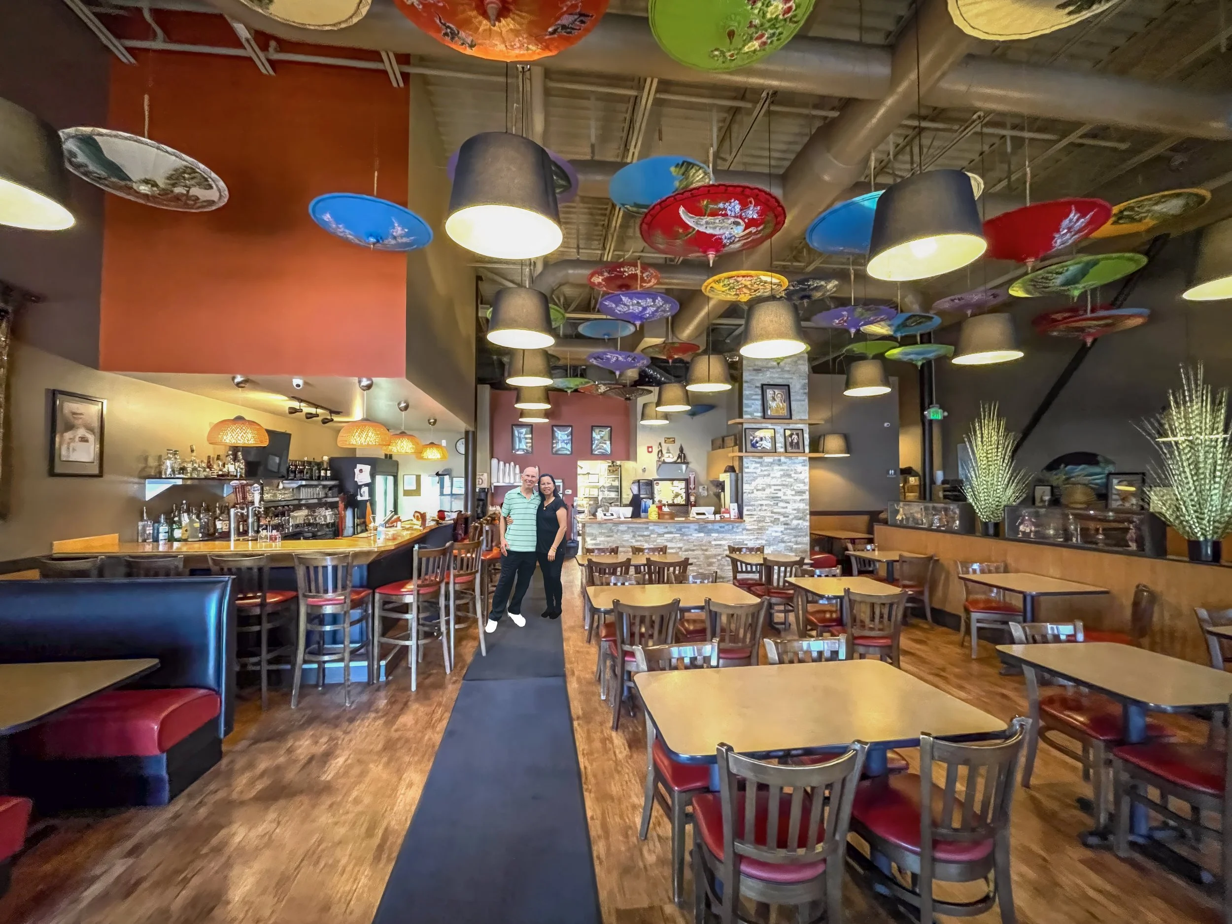 Interior of Thai Pot Cafe Denver - custom handmade bar by the owner with colorful Thai umbrellas hanging from the ceiling brought from Thailand. Modern, bright and comfortable dining space with full bar and full service.