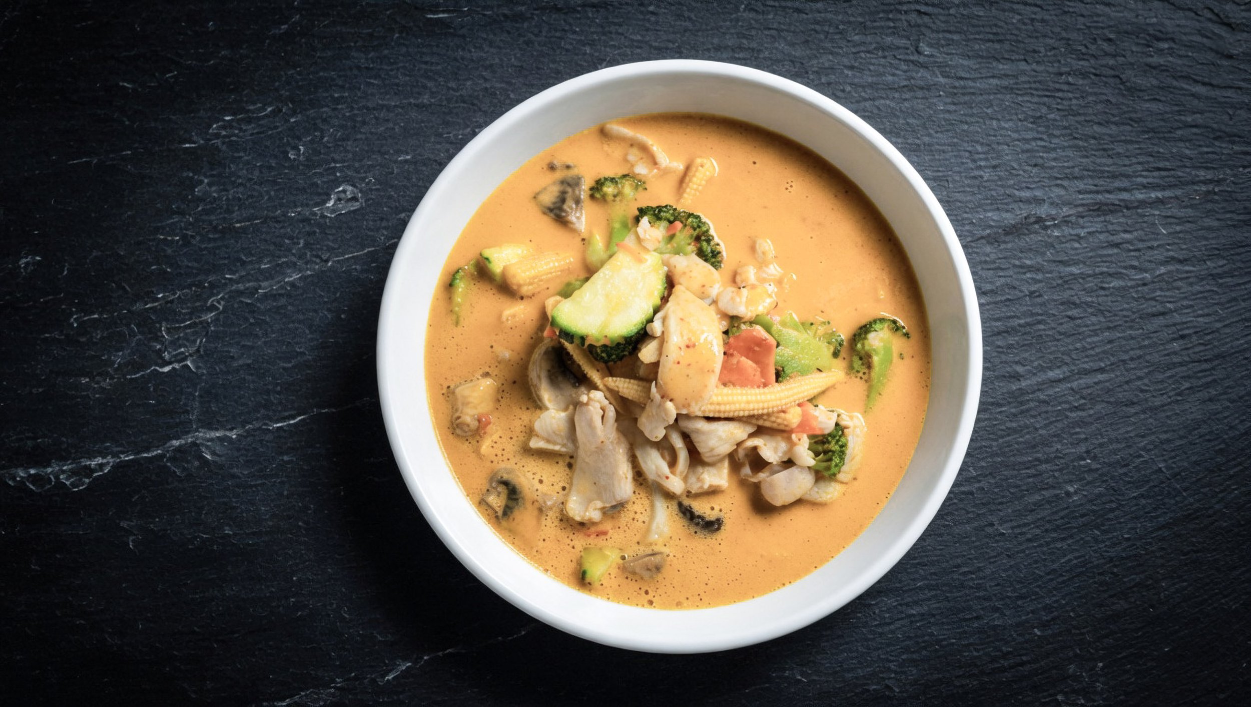 Panang curry bowl - creamy coconut milk with mushrooms, baby corn, zucchini, broccoli, carrots, kaffir lime leaves and Panang peanut curry paste. Choice of chicken, beef, shrimp or seafood. Gluten-free, vegan & vegetarian jasmine rice.