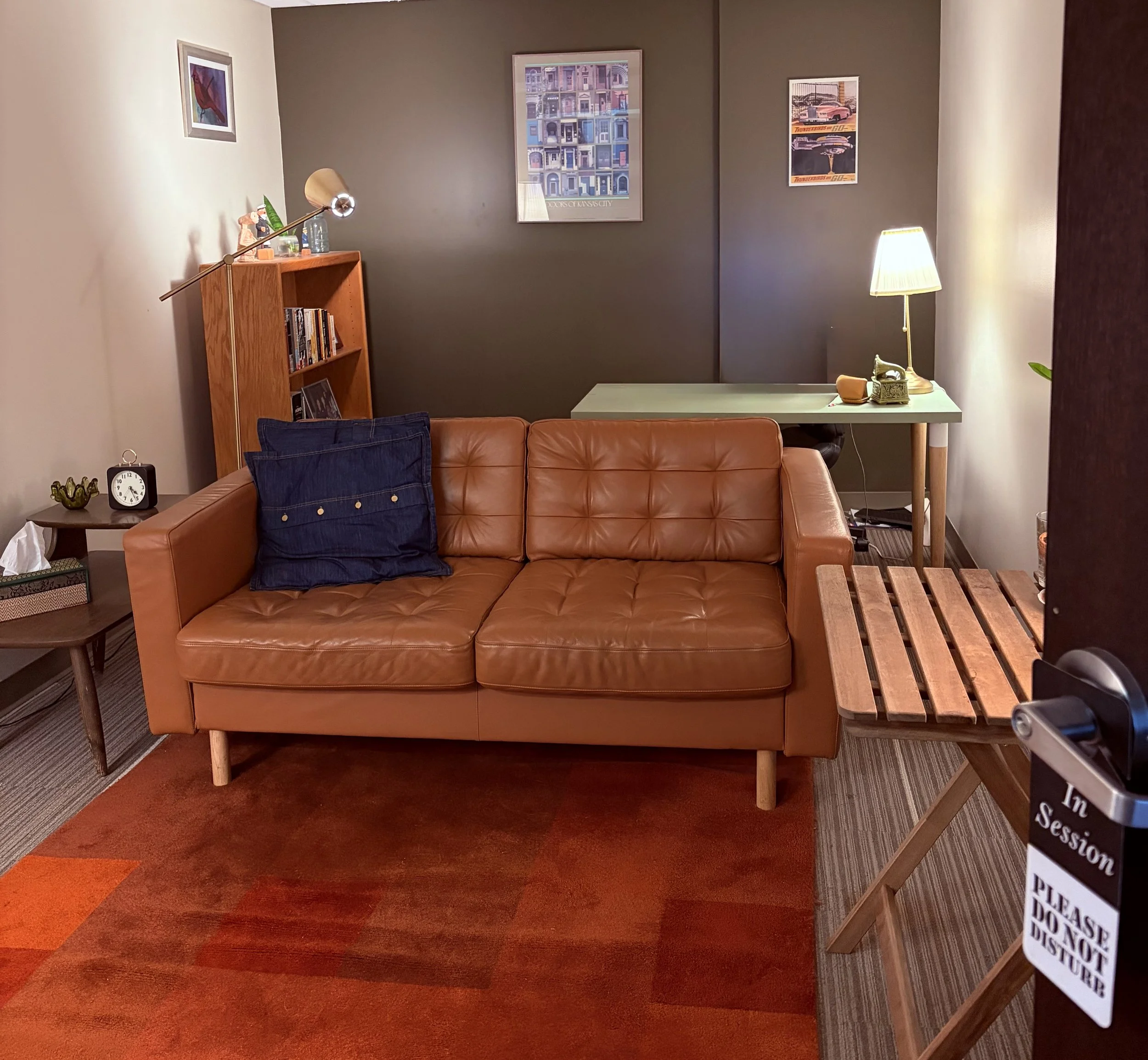 Office of Elliott Seymour, LPC in Kansas City. A brown leather couch for clients sits in the center of the office.