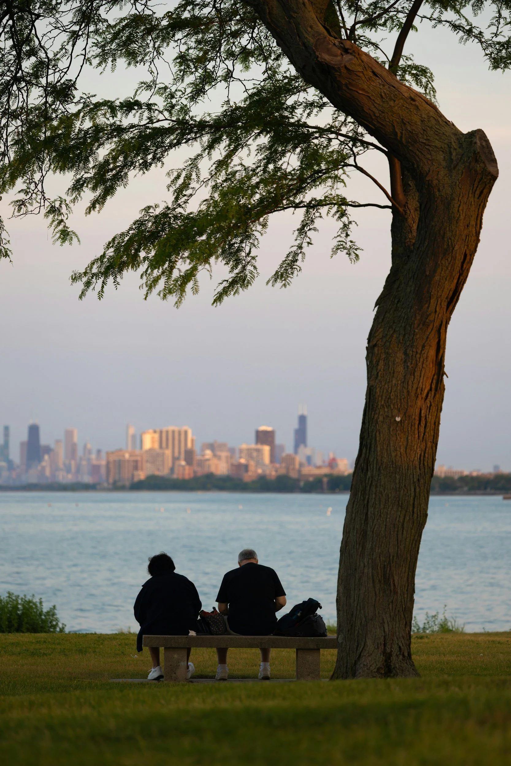 Older couple relaxing by the water with the Detroit skyline in the distance.