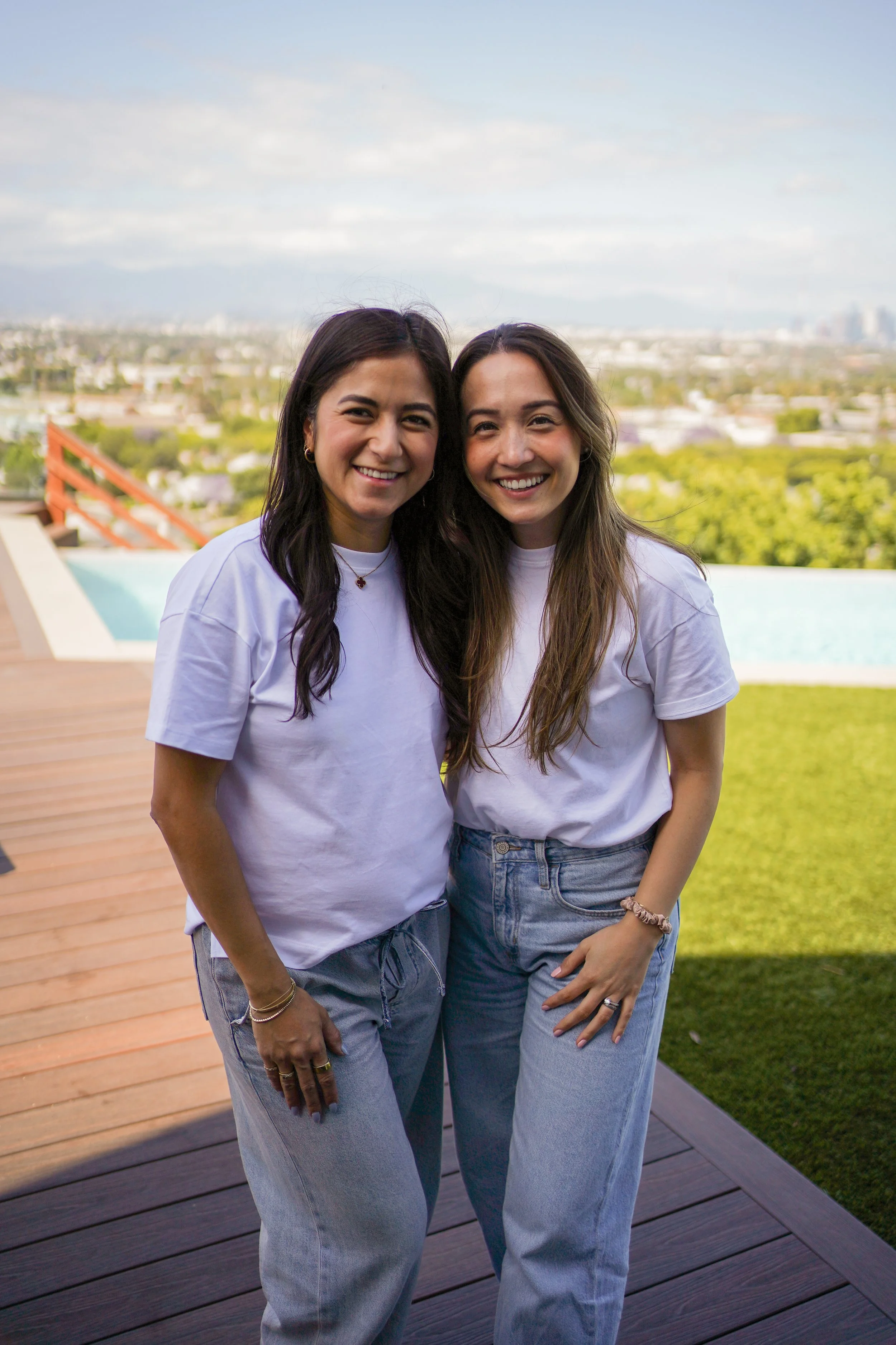 Tori and Ash from Curated by AT standing outside with the Los Angeles skyline in the background
