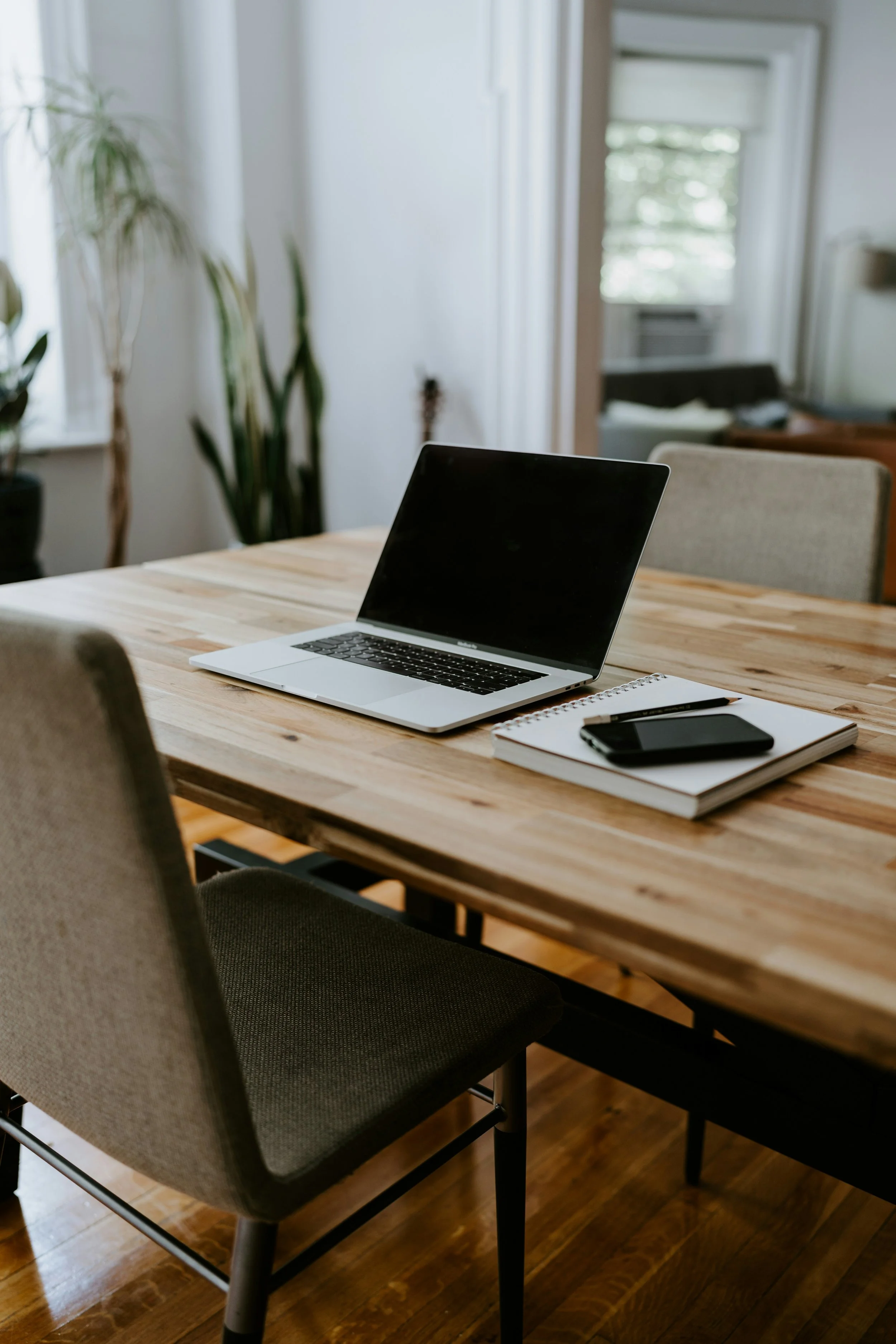 A photograph of a laptop and a notebook at a table to demonstrate the online intensives incubator option for therapists looking to grow their intensive practice.