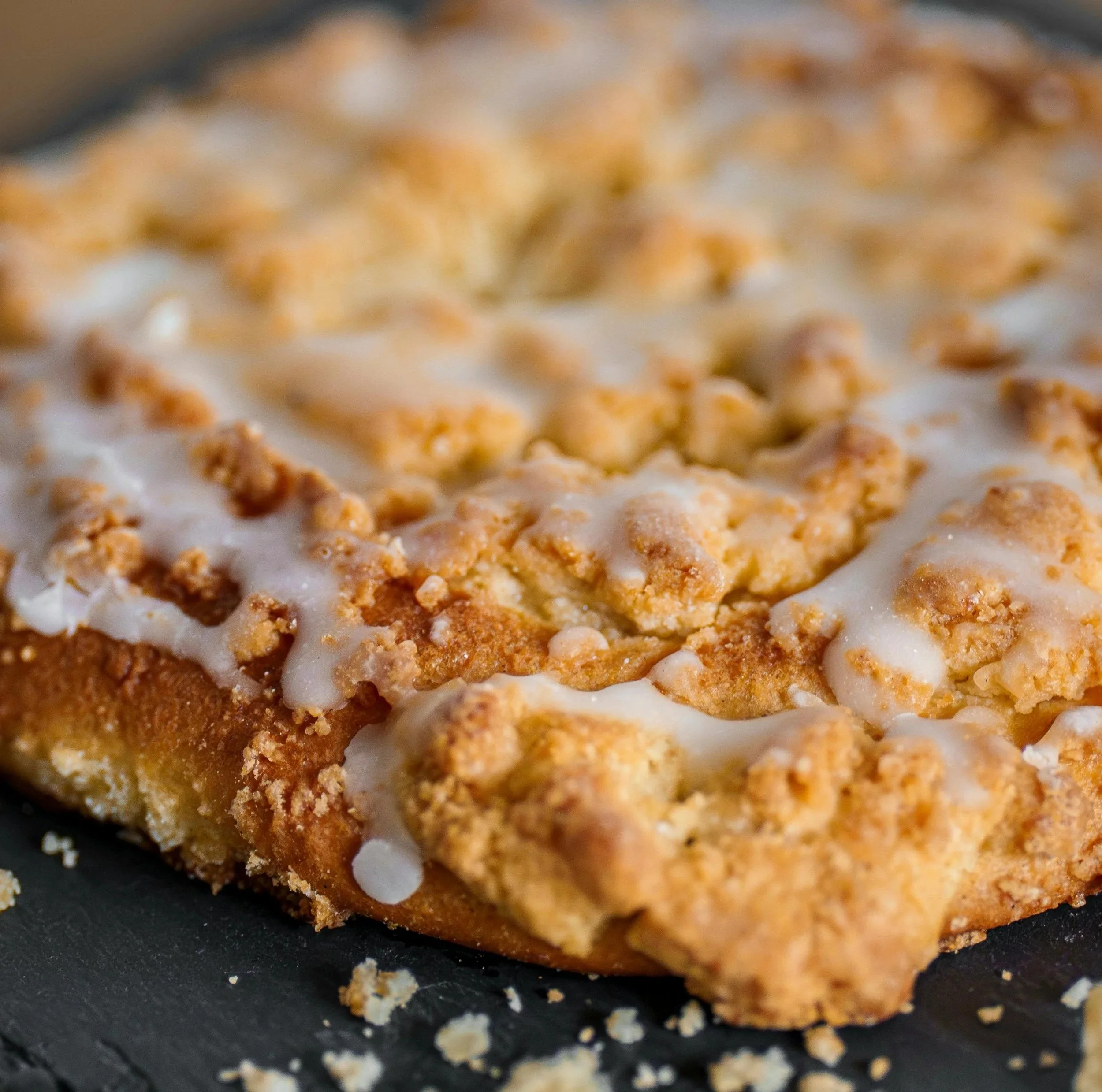 Close-up of a toasted bread slice with a spread of icing and crunchy cereal topping.