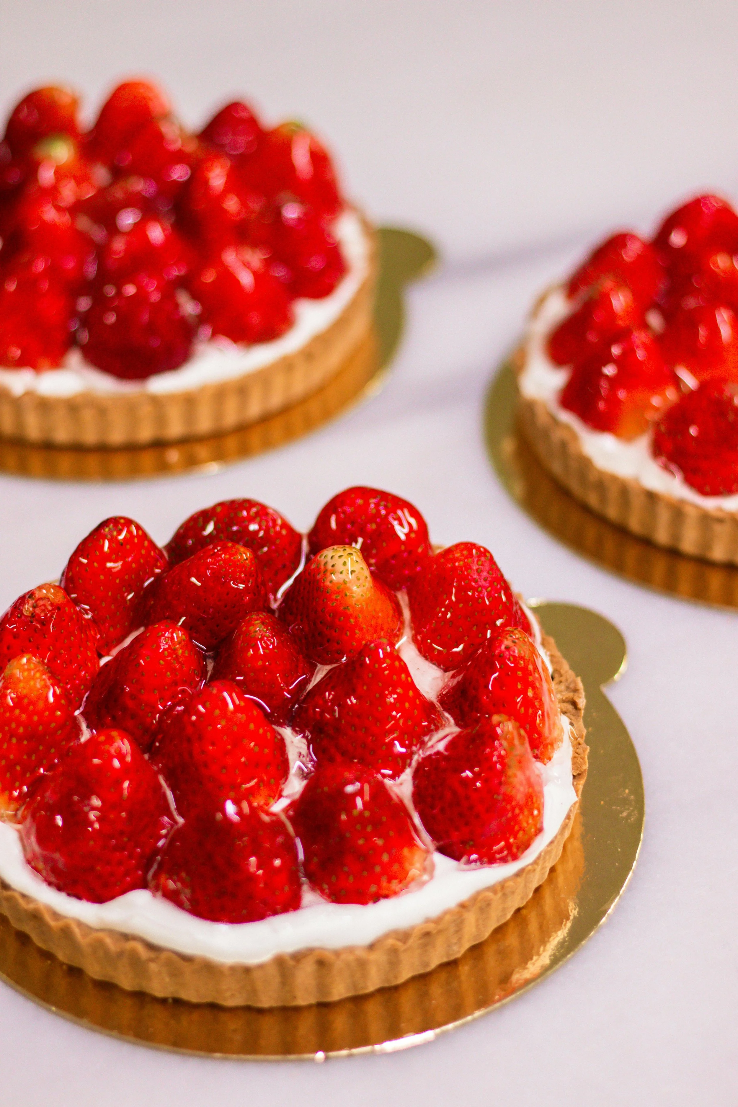Close-up of a strawberry tart with fresh strawberries on a golden base.