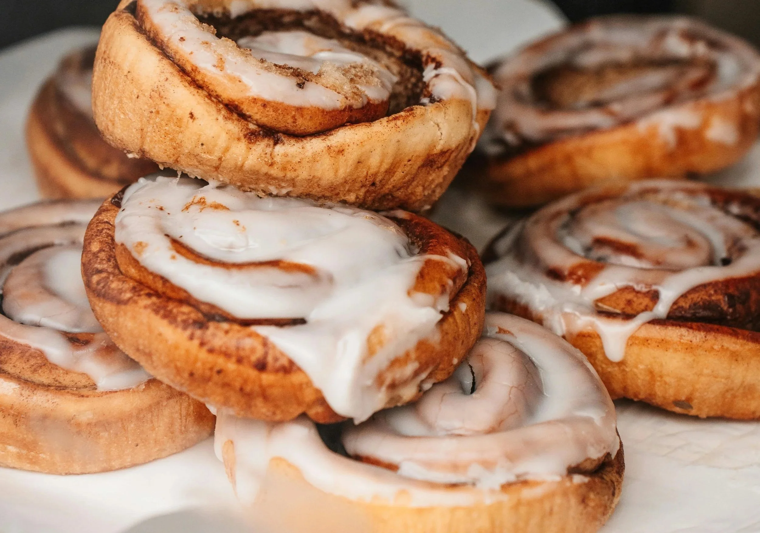 Close-up of cinnamon rolls topped with icing.