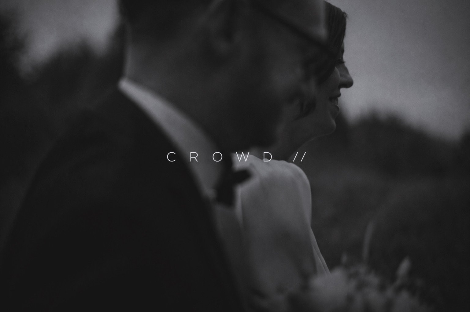 Black and white image of a smiling man and woman, close-up, with the word 'CROWD' overlaid in the center.