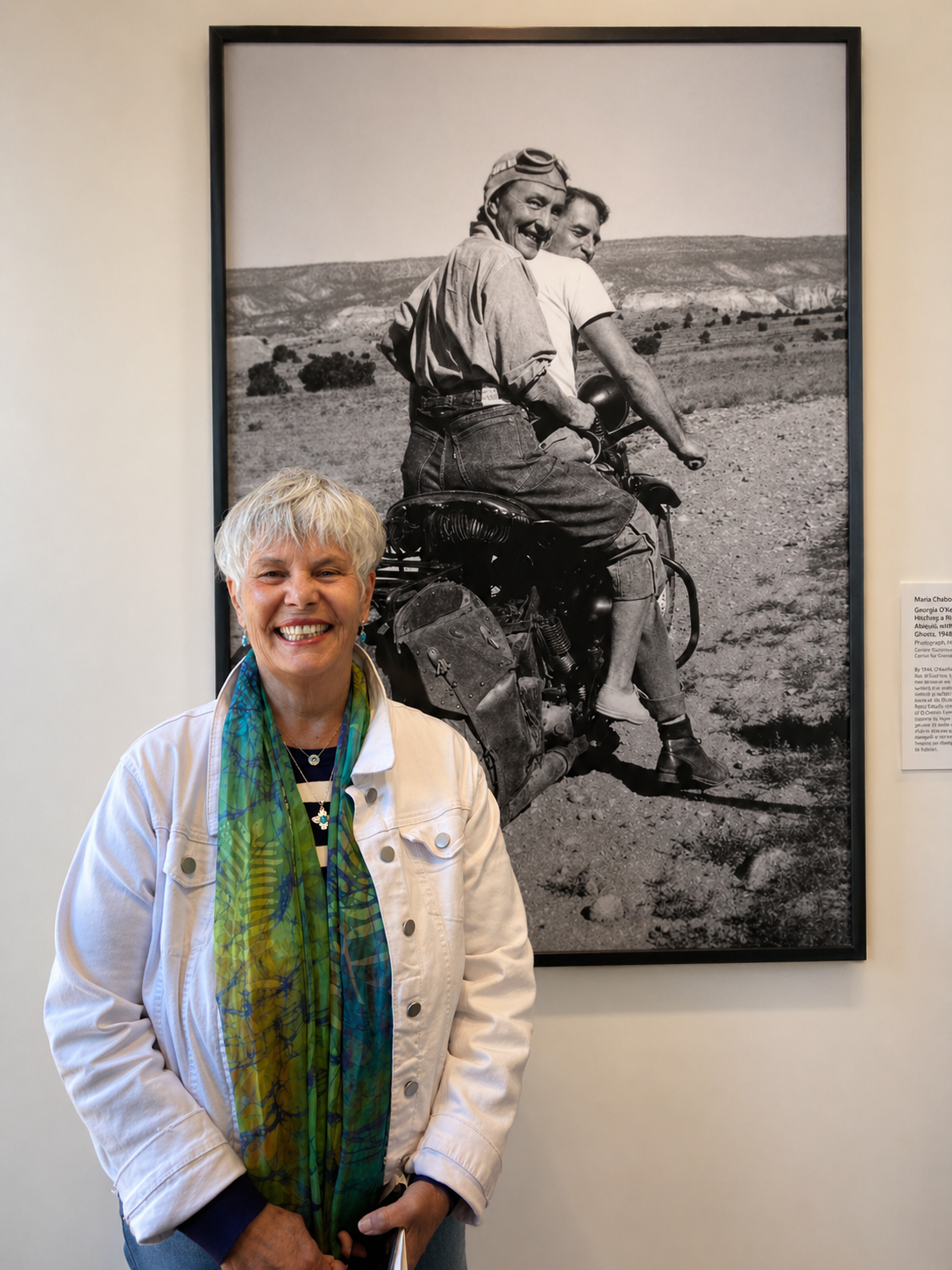 Terra smiling warmly in front of a photograph of Georgia O'Keefe and Alfred Stieglitz.