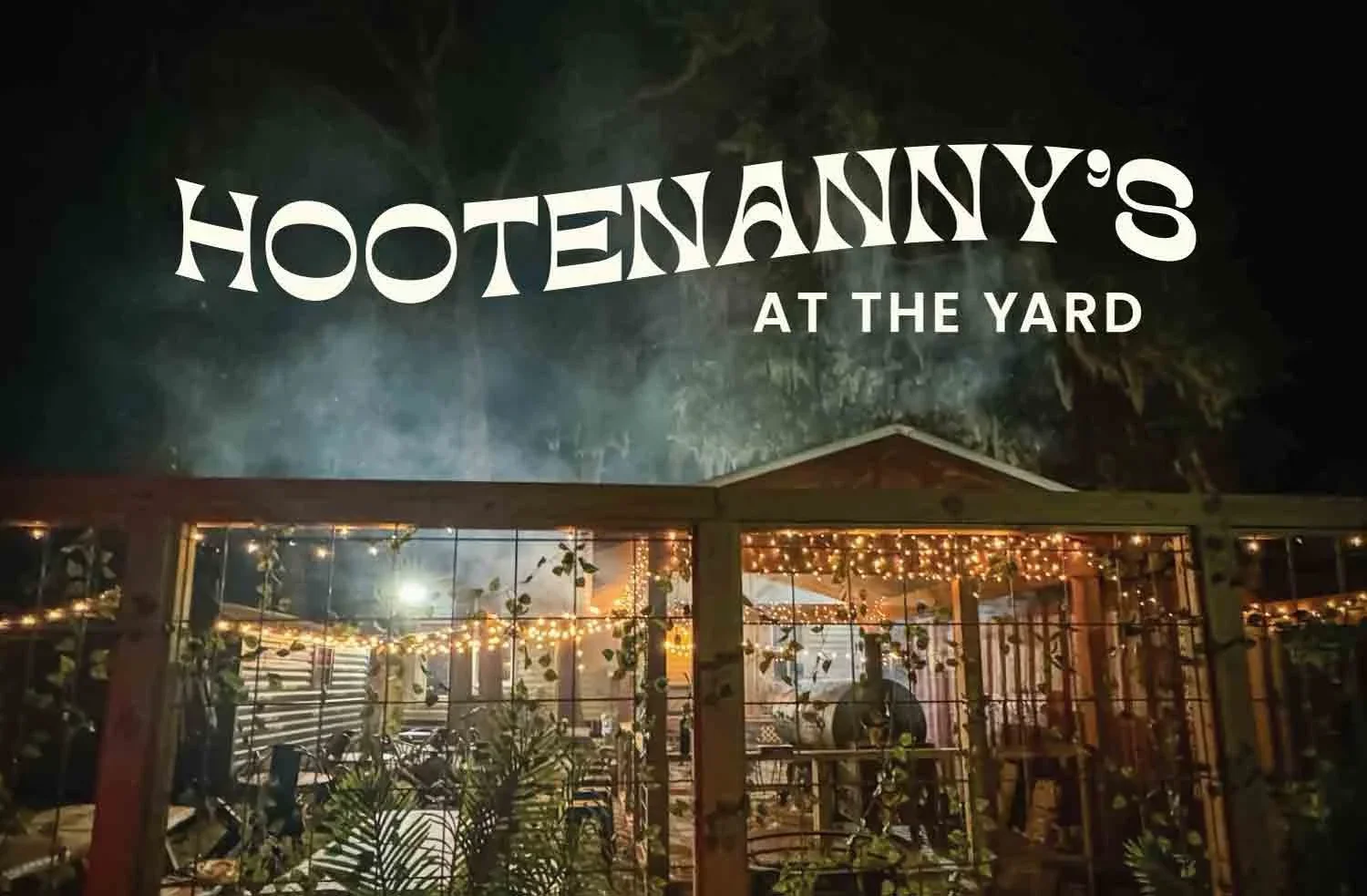 Sign reading "Hootenanny's at the Yard" above a decorated outdoor patio with string lights at night.