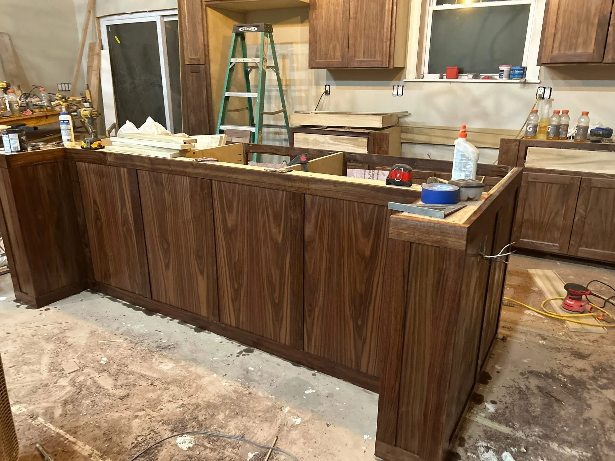 A kitchen island under construction with wooden cabinets.