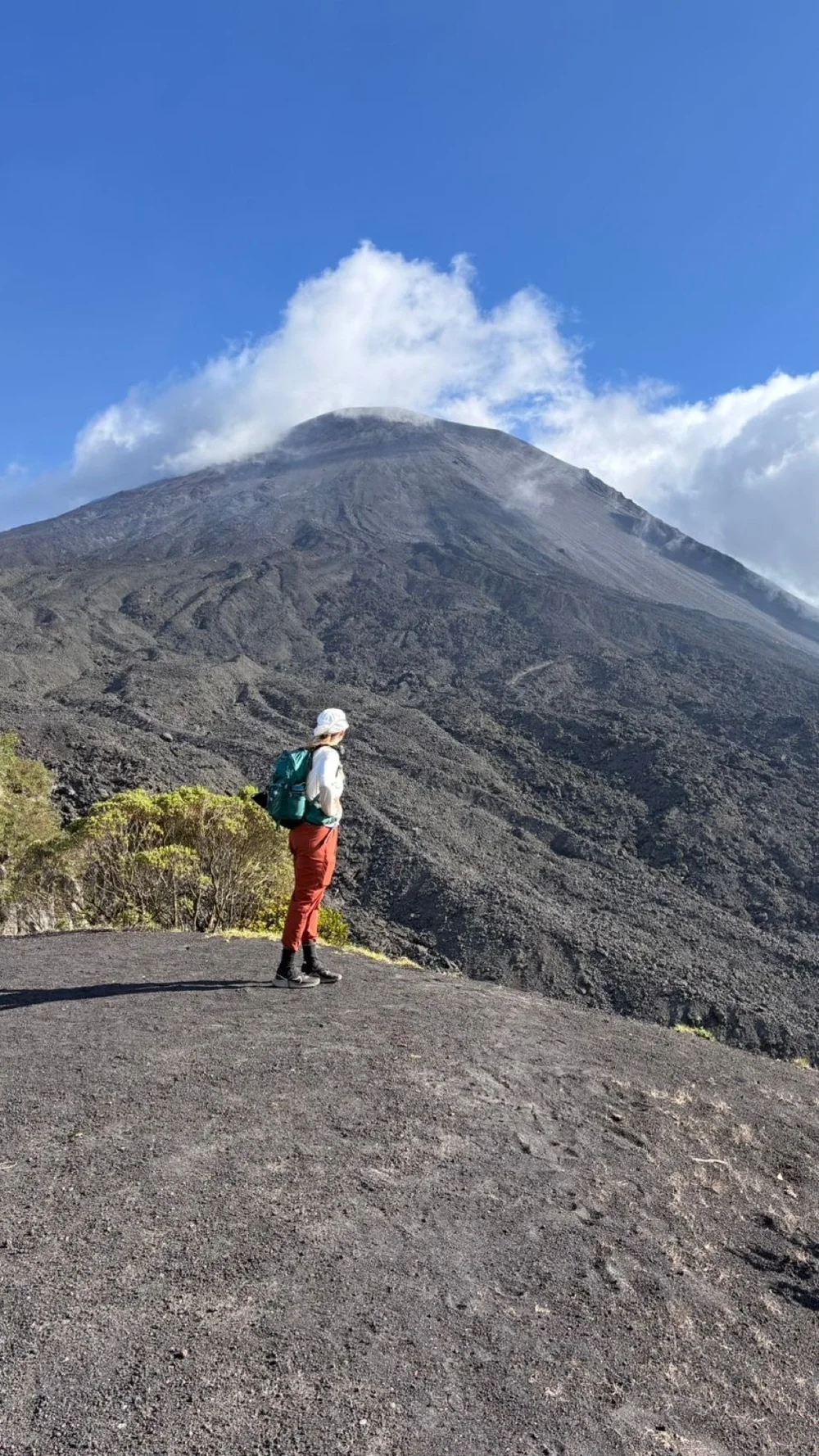 Hiker facing the Pacaya cone on the lava field