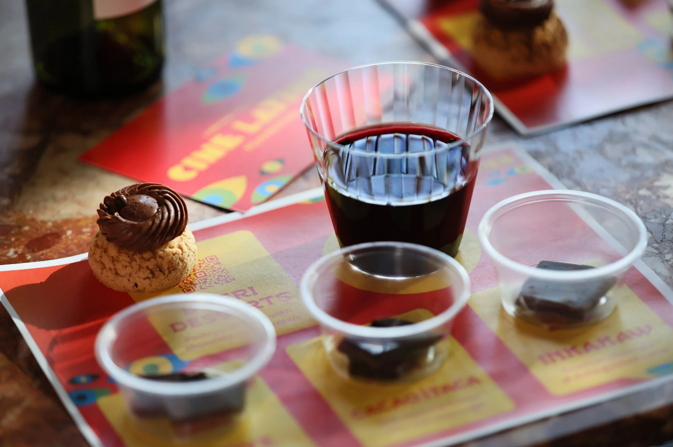 Placemat with glass of wine, the three chocolates, and the desert for the Cine Latino tasting